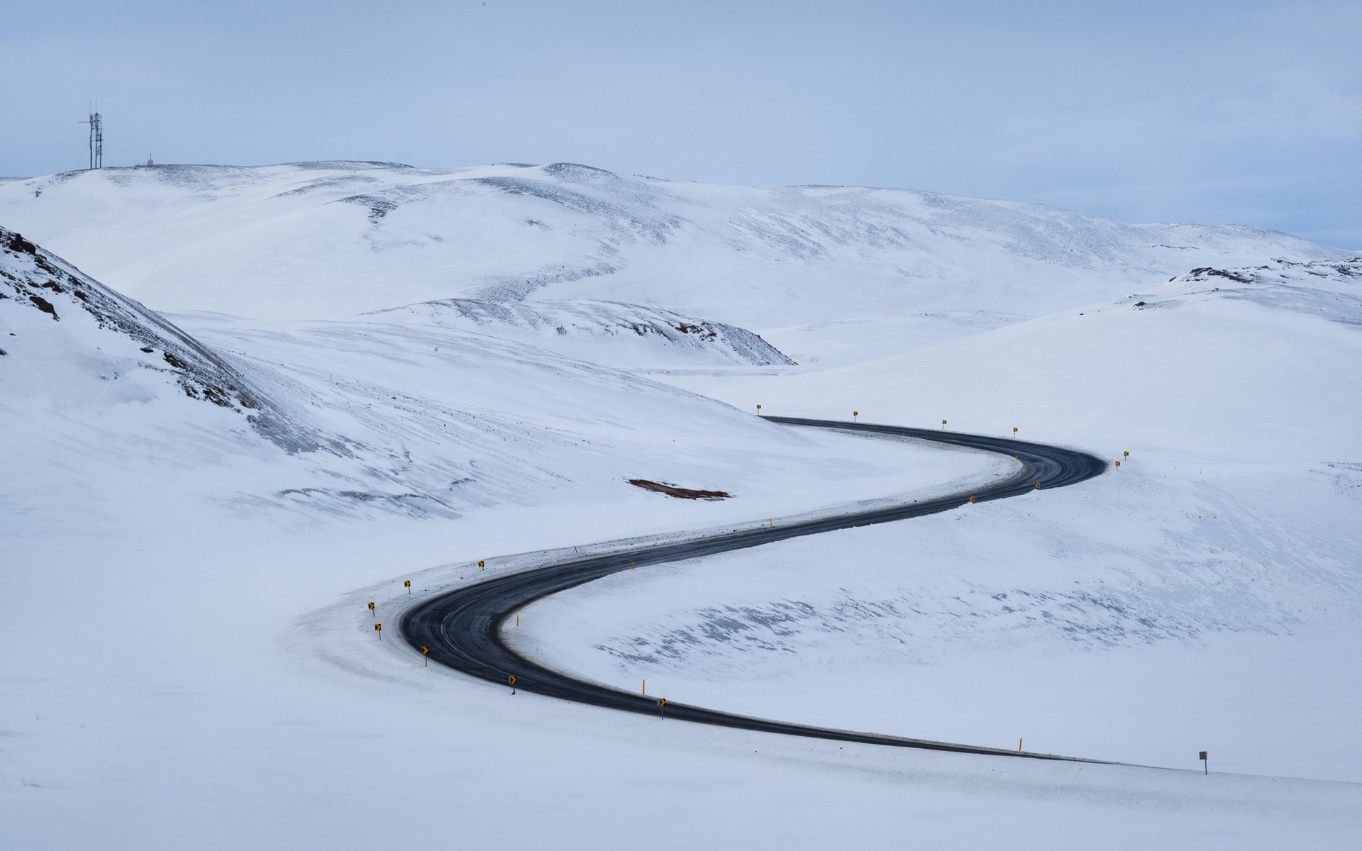 Winding road through a snowy landscape HD Wallpaper