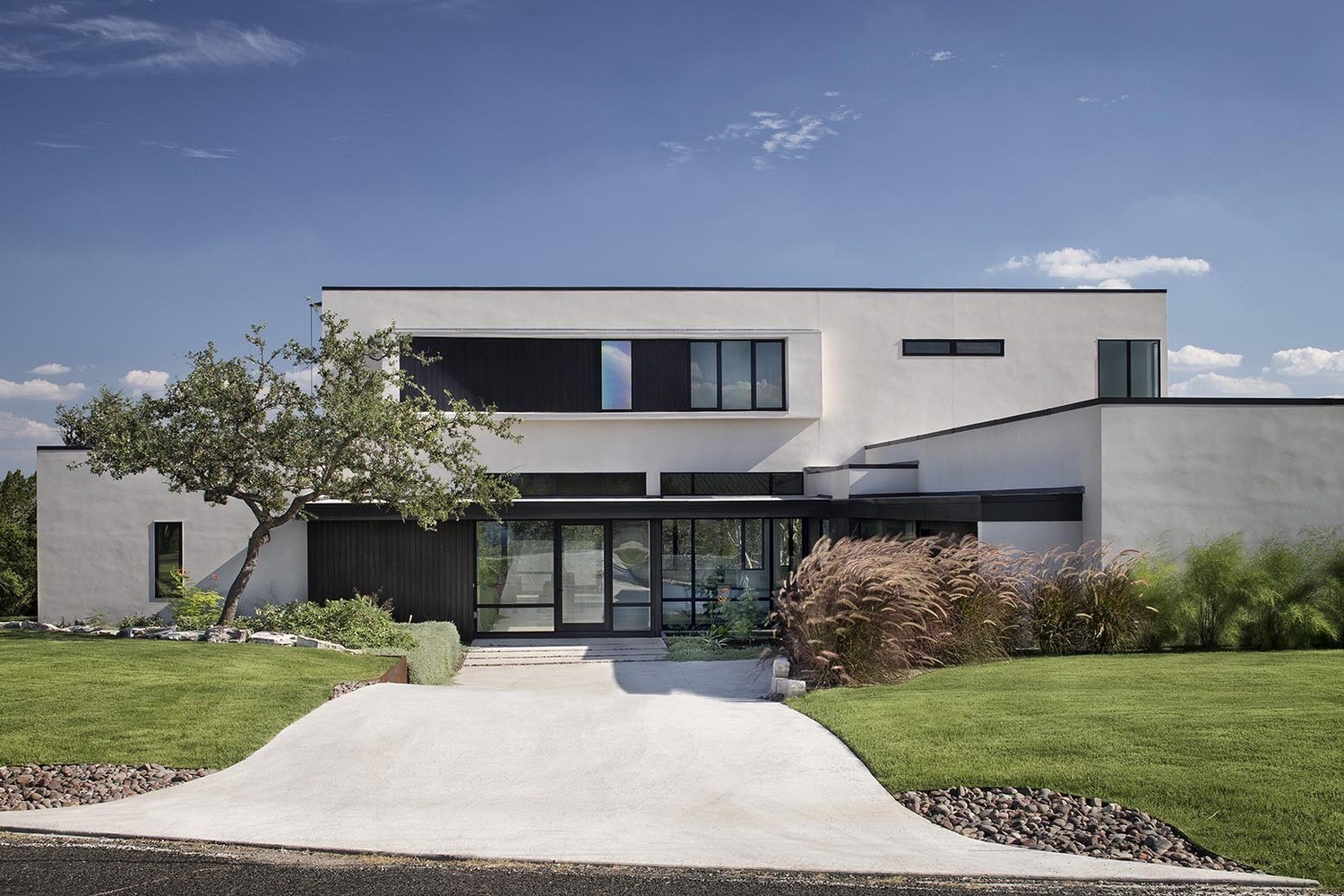 Modern white stucco house with large windows and landscaping HD Wallpaper