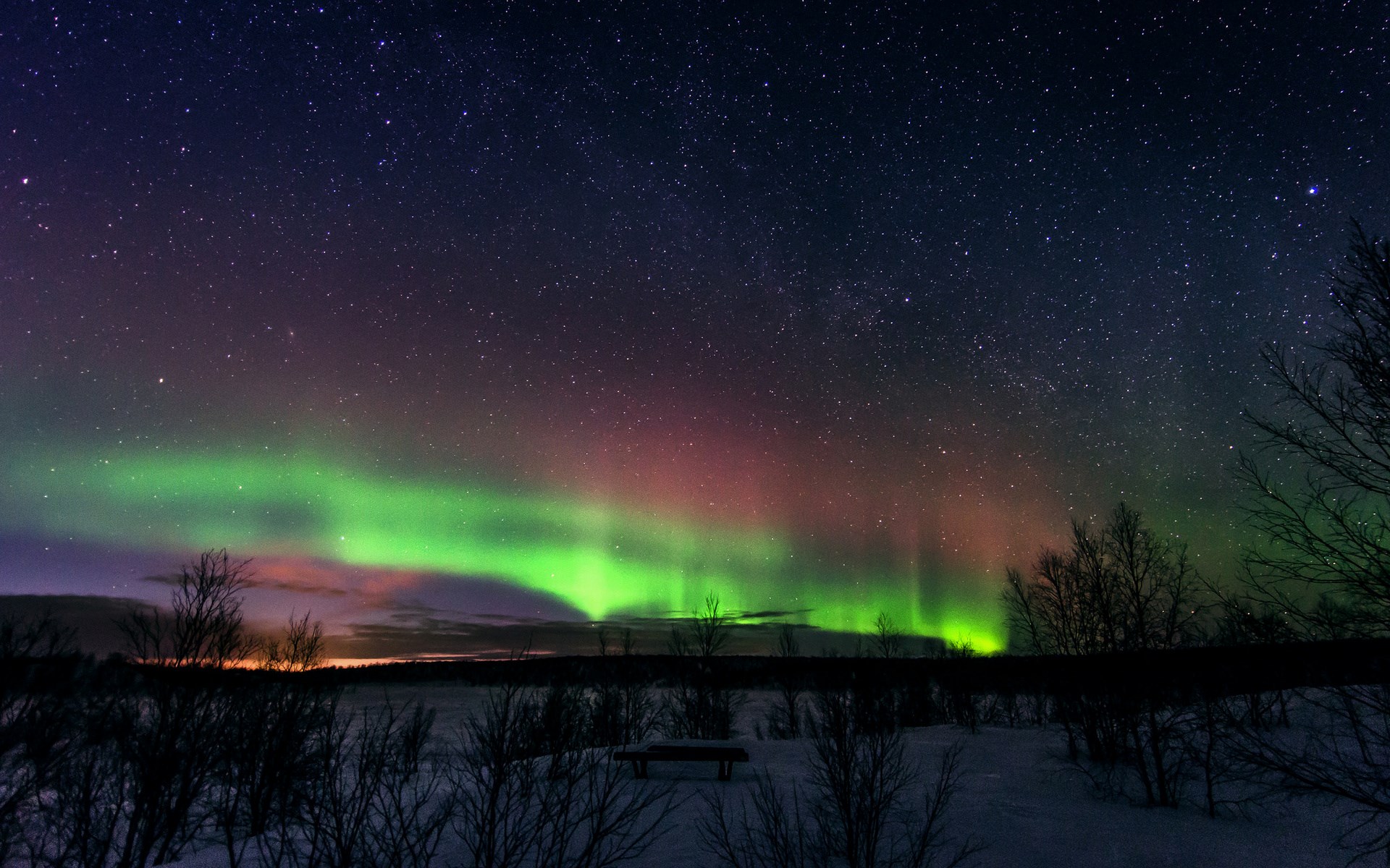 Aurora Borealis over a snowy landscape HD Wallpaper