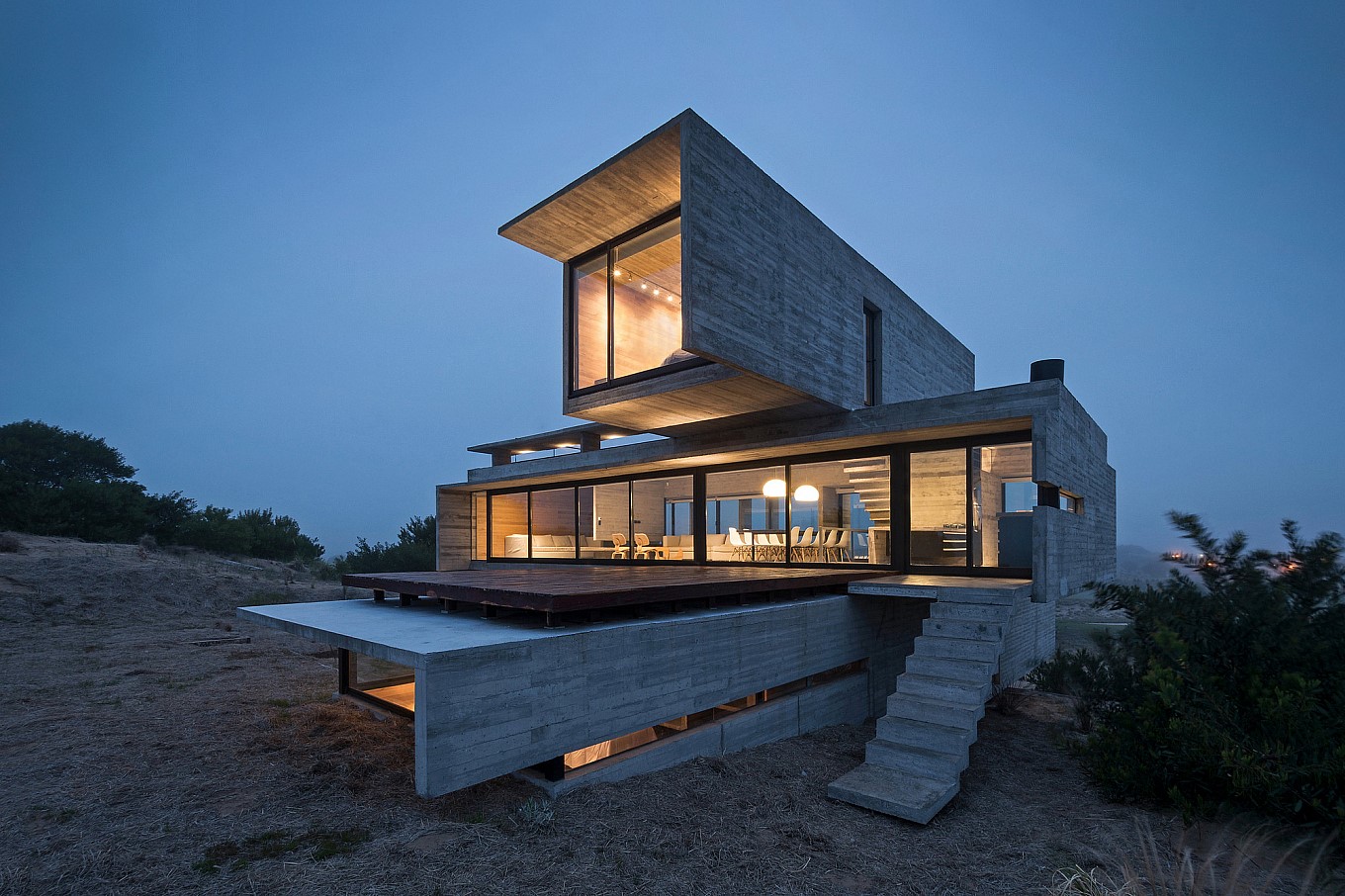 Modern concrete house with large windows at dusk HD Wallpaper