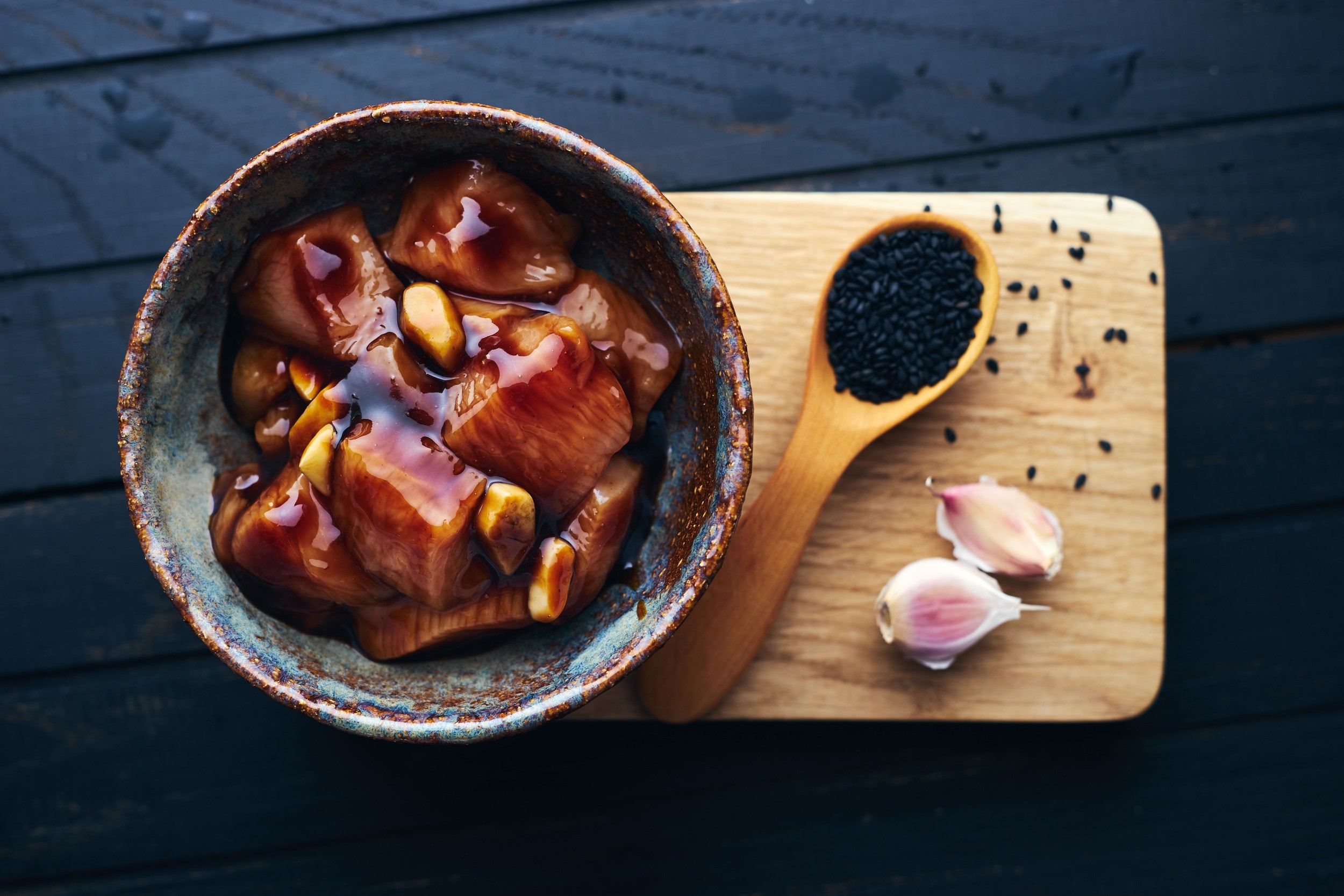 Bowl of marinated chicken with garlic and black sesame seeds HD Wallpaper