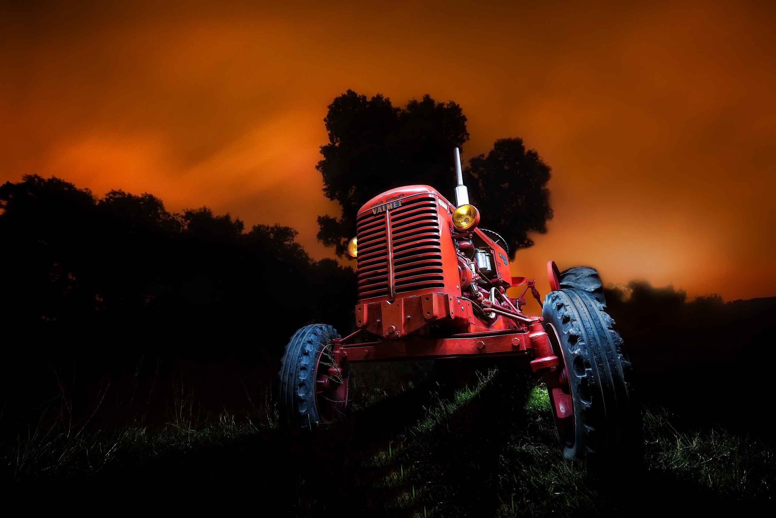 Red Valmet tractor in a dark field at sunset HD Wallpaper