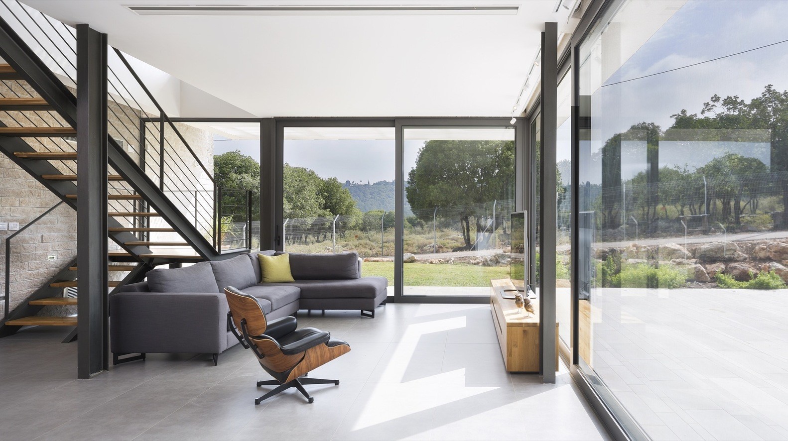 Modern living room with stairs and large windows HD Wallpaper