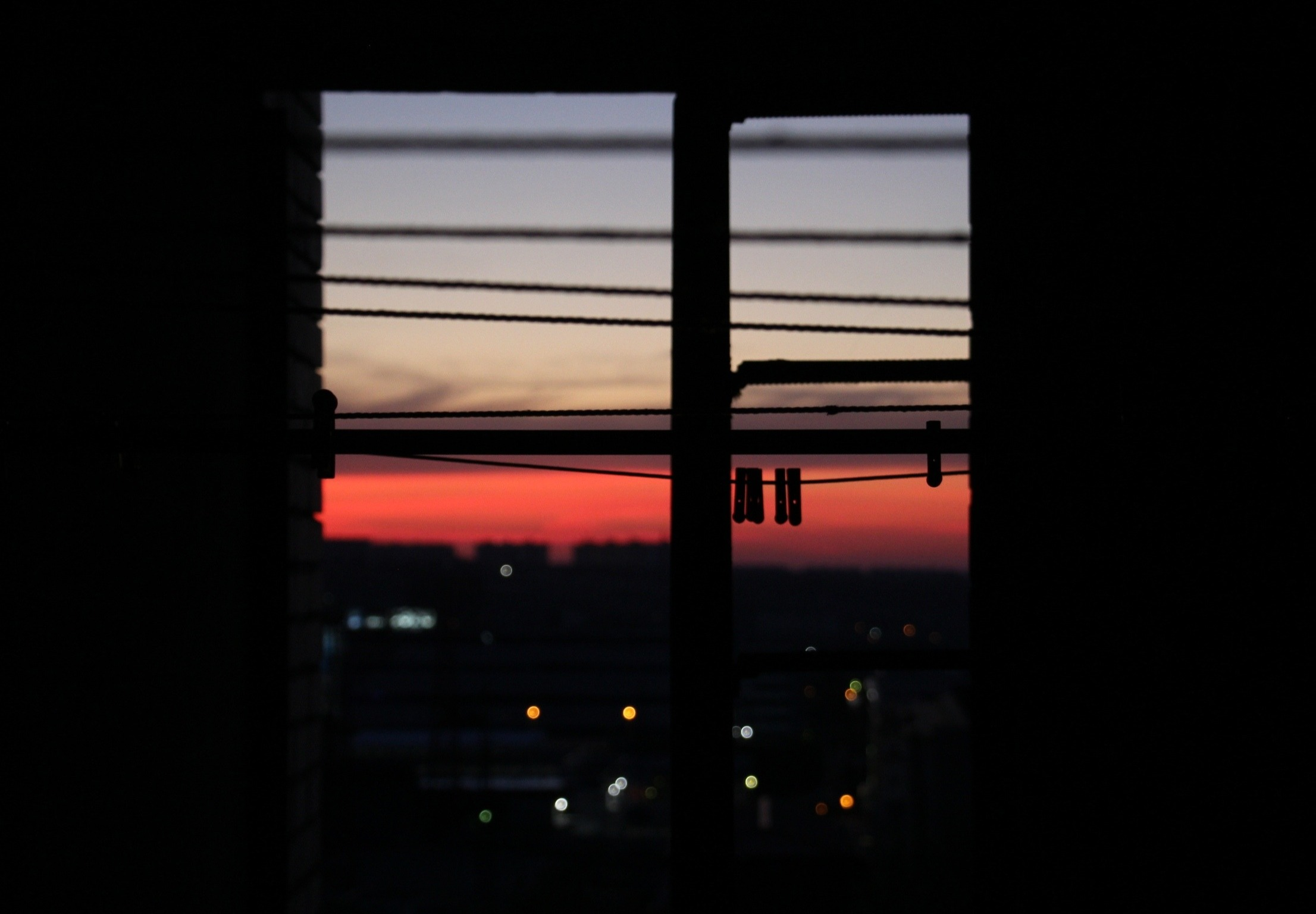 Sunset over city seen through window with clothespins HD Wallpaper