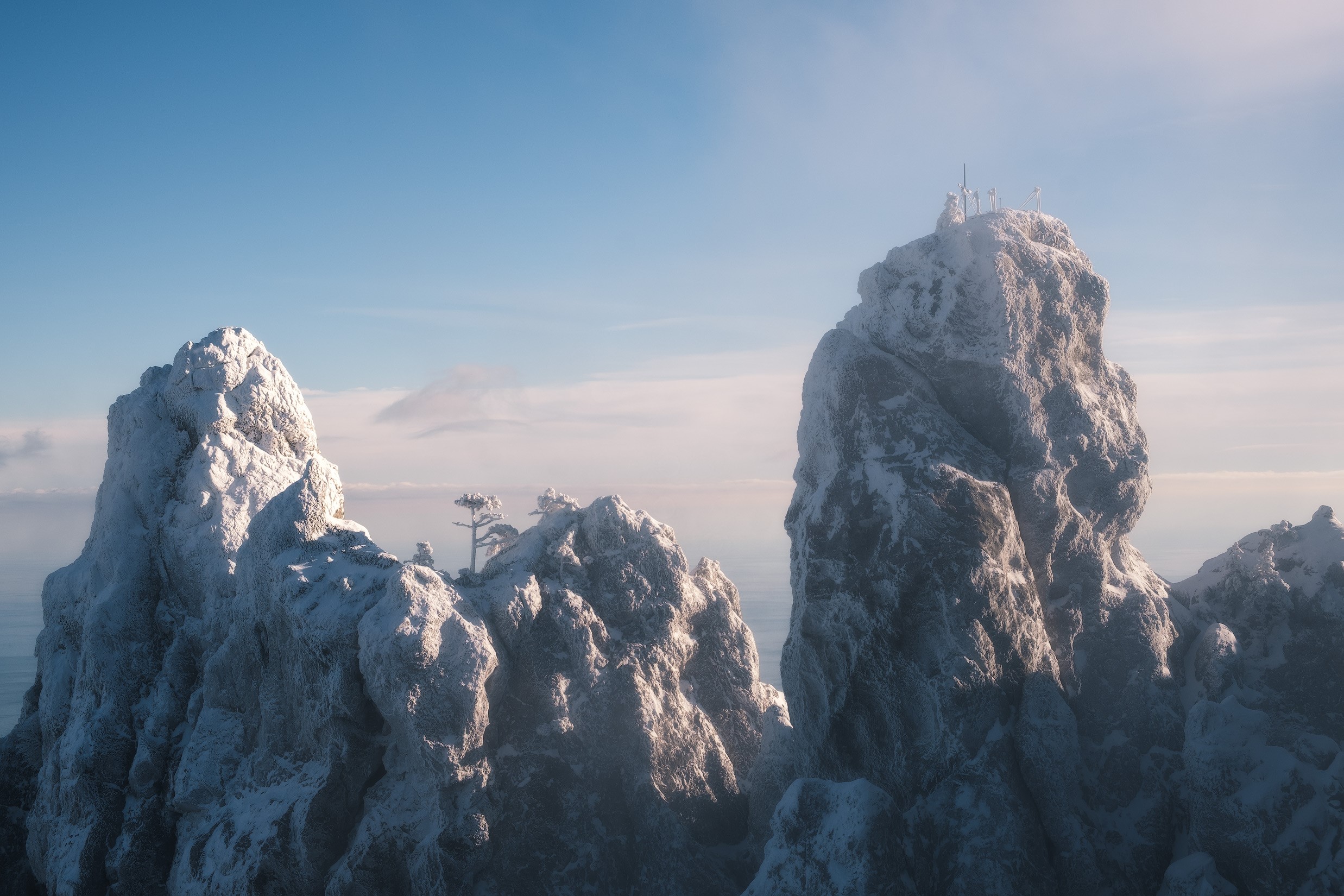 Snow-covered rocky peaks under a clear blue sky HD Wallpaper