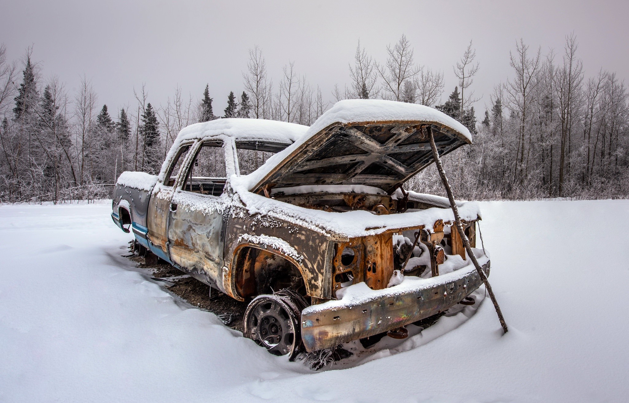 Abandoned snow-covered truck in winter forest HD Wallpaper