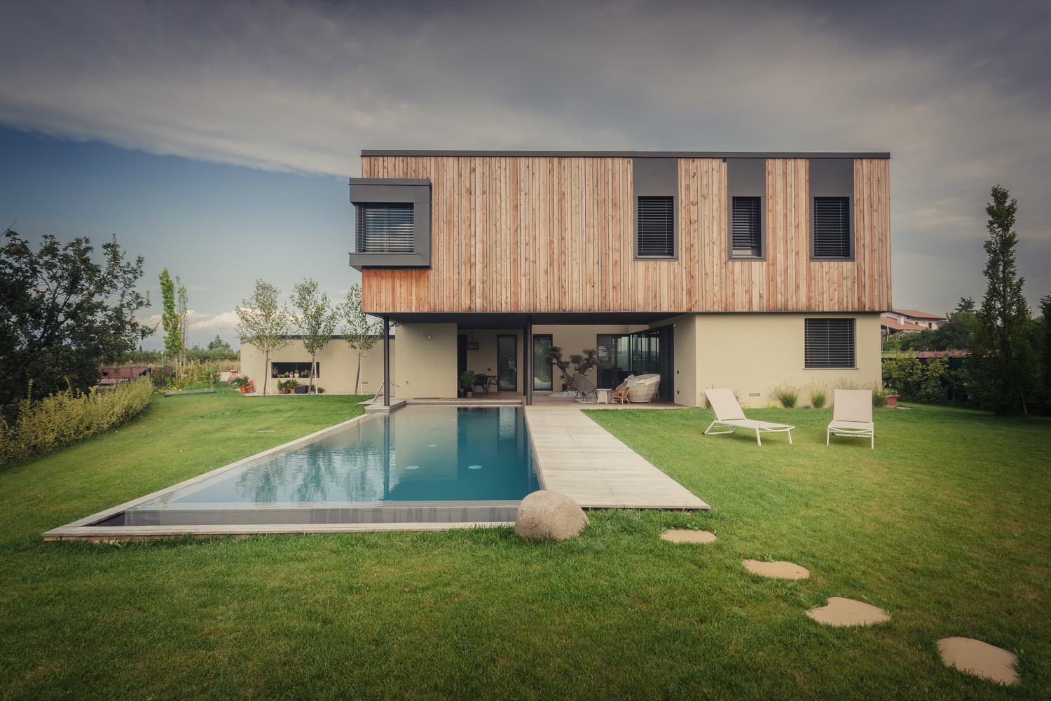 Modern house with swimming pool and lounge chairs HD Wallpaper
