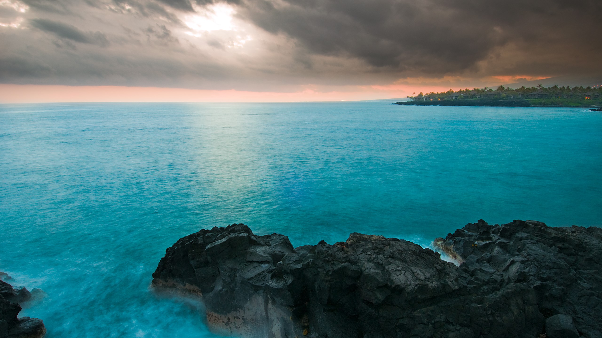 Ocean waves crash against rocky shore under stormy sky HD Wallpaper