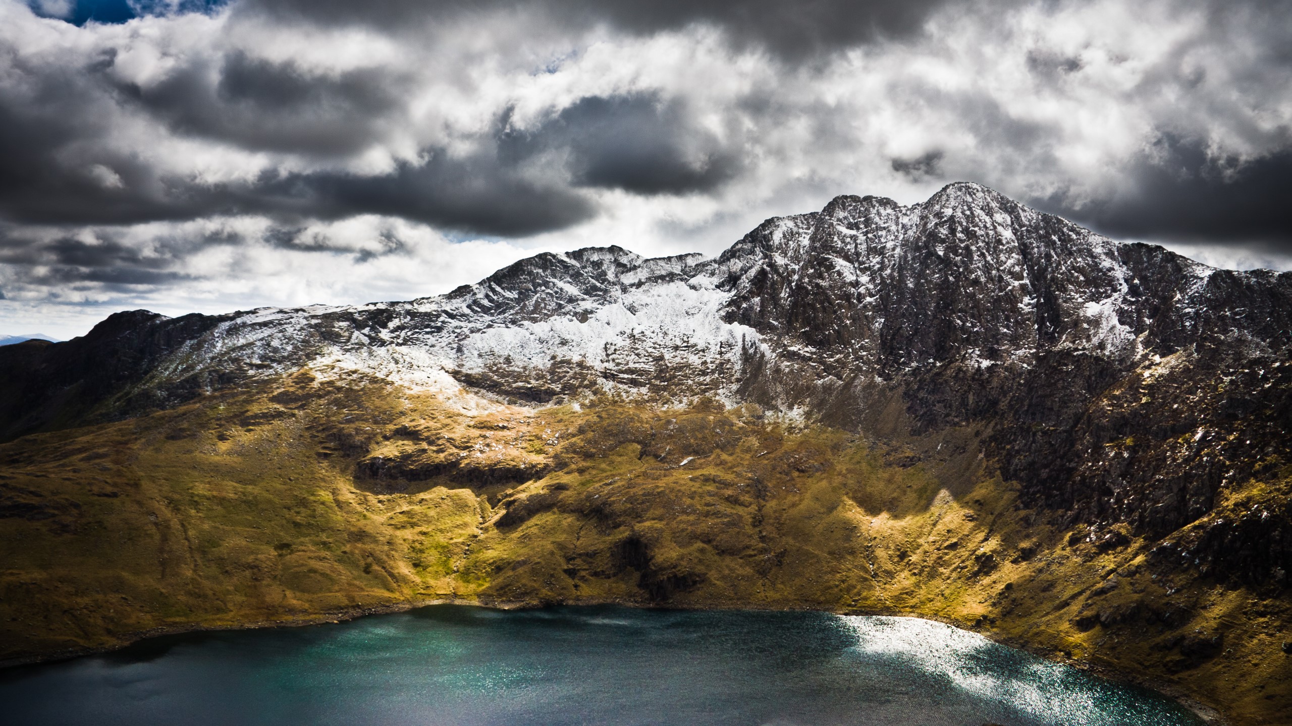 Snow-capped mountains overlooking a lake under cloudy skies HD Wallpaper