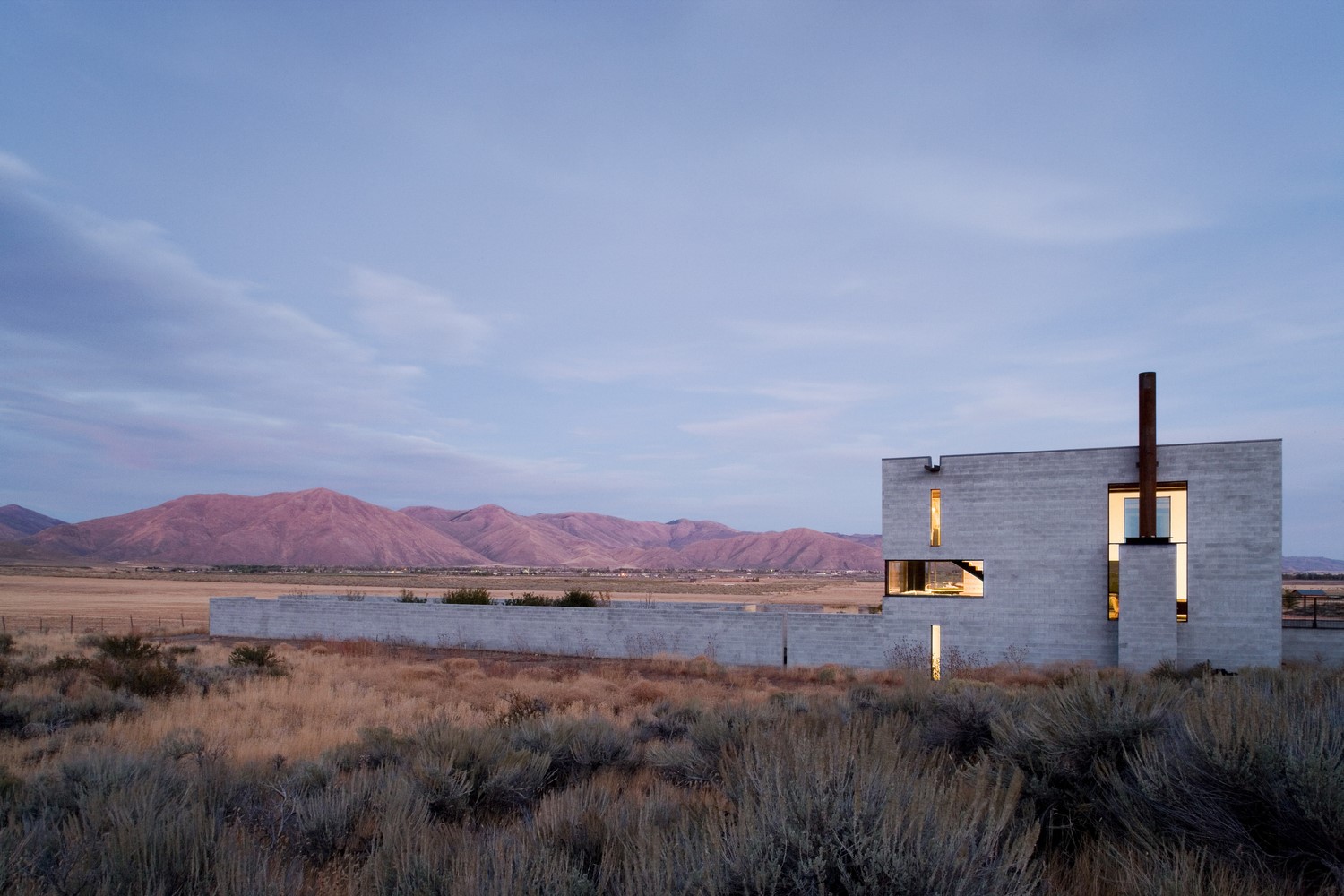 Modern concrete house with chimney in a desert landscape HD Wallpaper