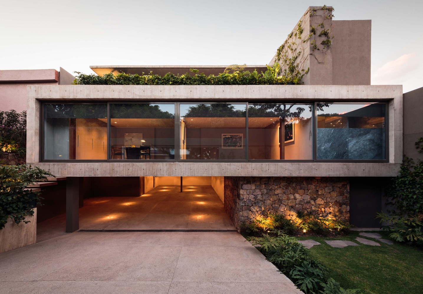 Modern concrete house with large windows and stone accents HD Wallpaper