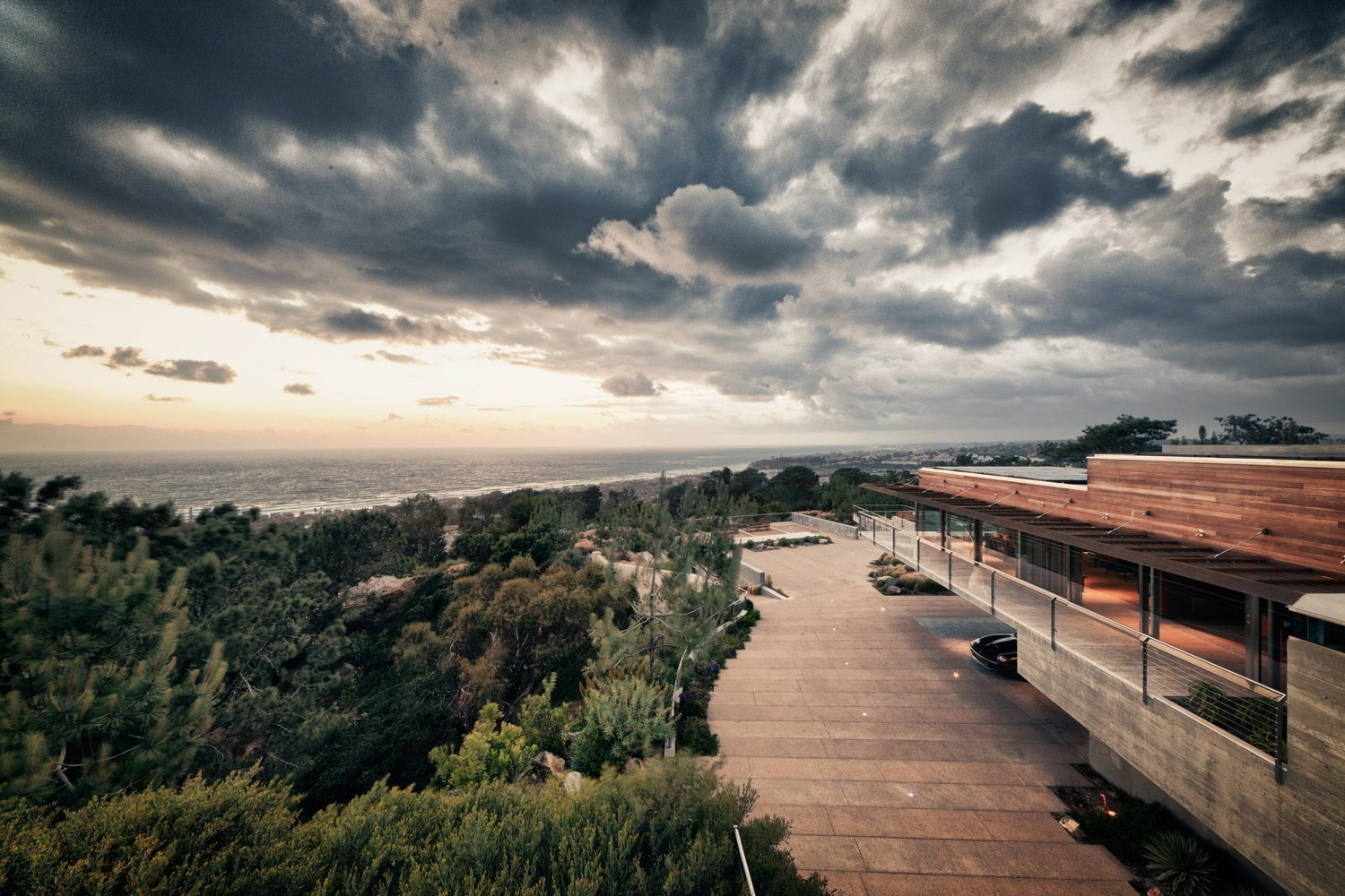 Modern house with ocean view under cloudy sky HD Wallpaper