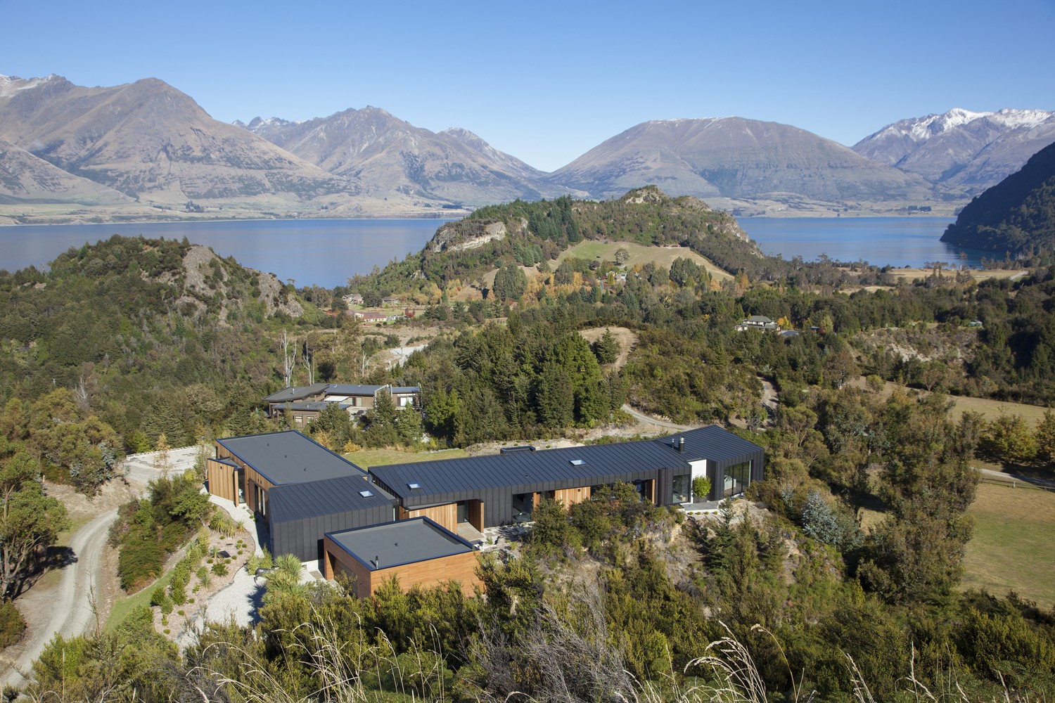 Modern house on a hill overlooking a lake and mountains HD Wallpaper