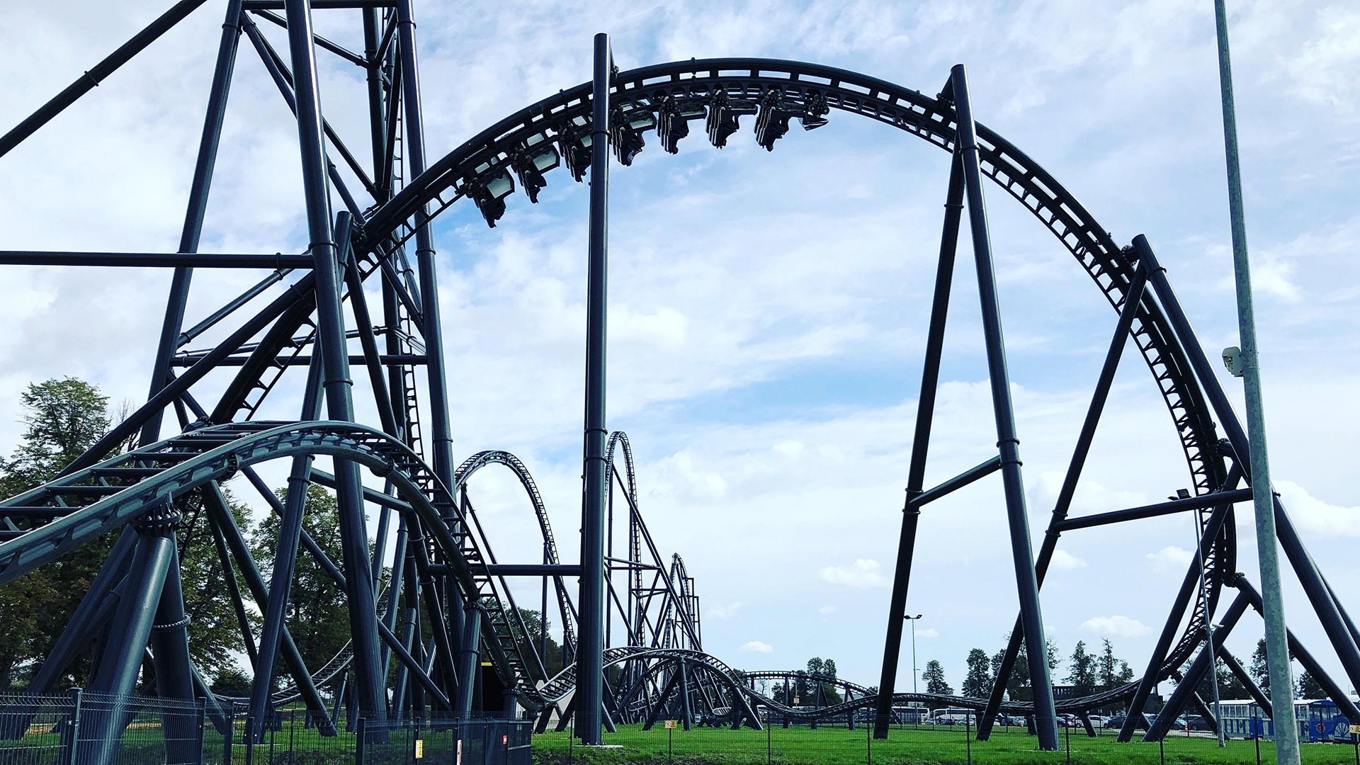 Roller coaster structure against a cloudy sky HD Wallpaper