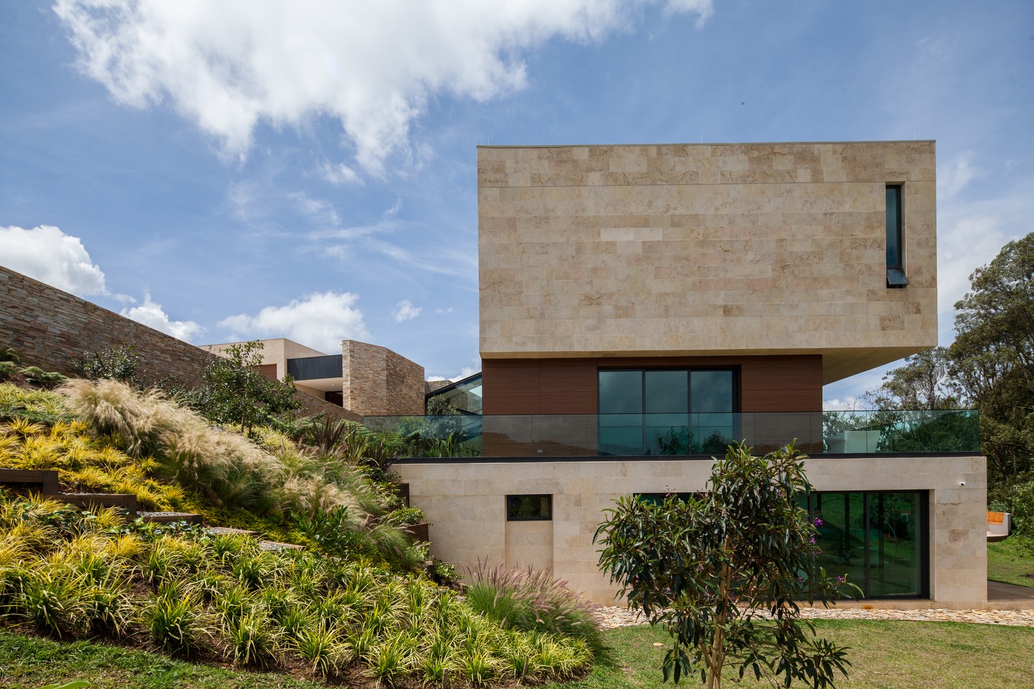 Modern stone mansion with landscaped hillside HD Wallpaper
