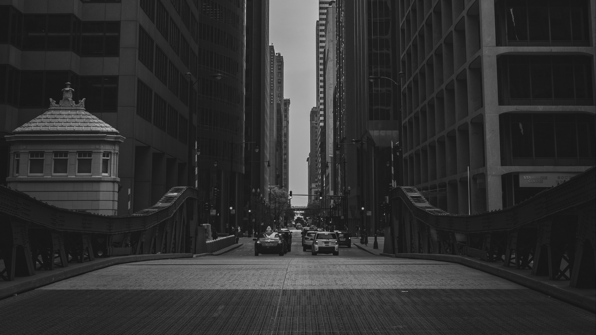 Monochrome view of a city bridge with cars and buildings HD Wallpaper