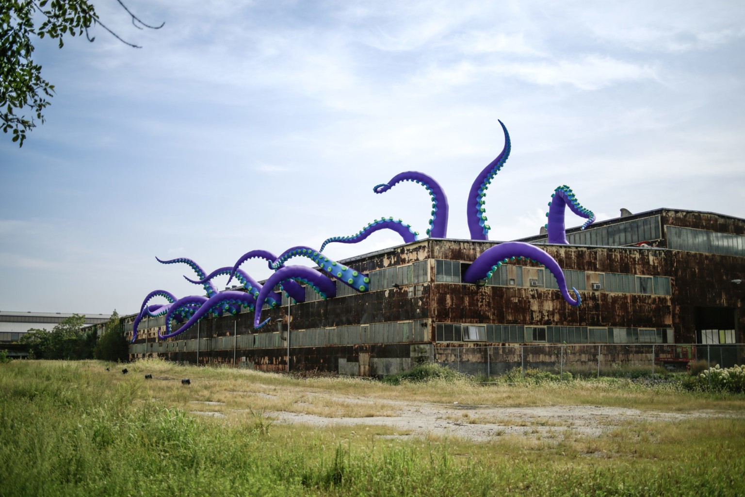 Purple octopus tentacles emerging from an abandoned building HD Wallpaper
