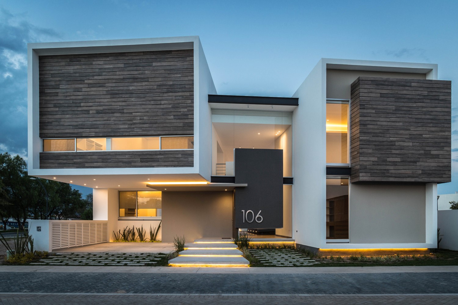 Modern house with wood accents and outdoor lighting HD Wallpaper