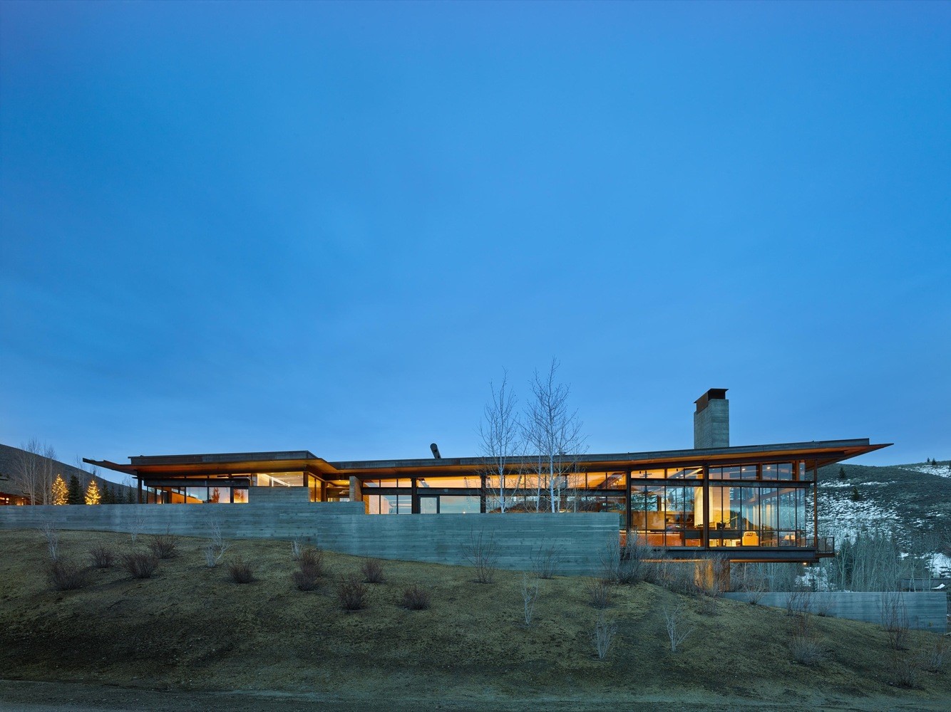 Modern luxury mansion with glass walls and concrete base HD Wallpaper