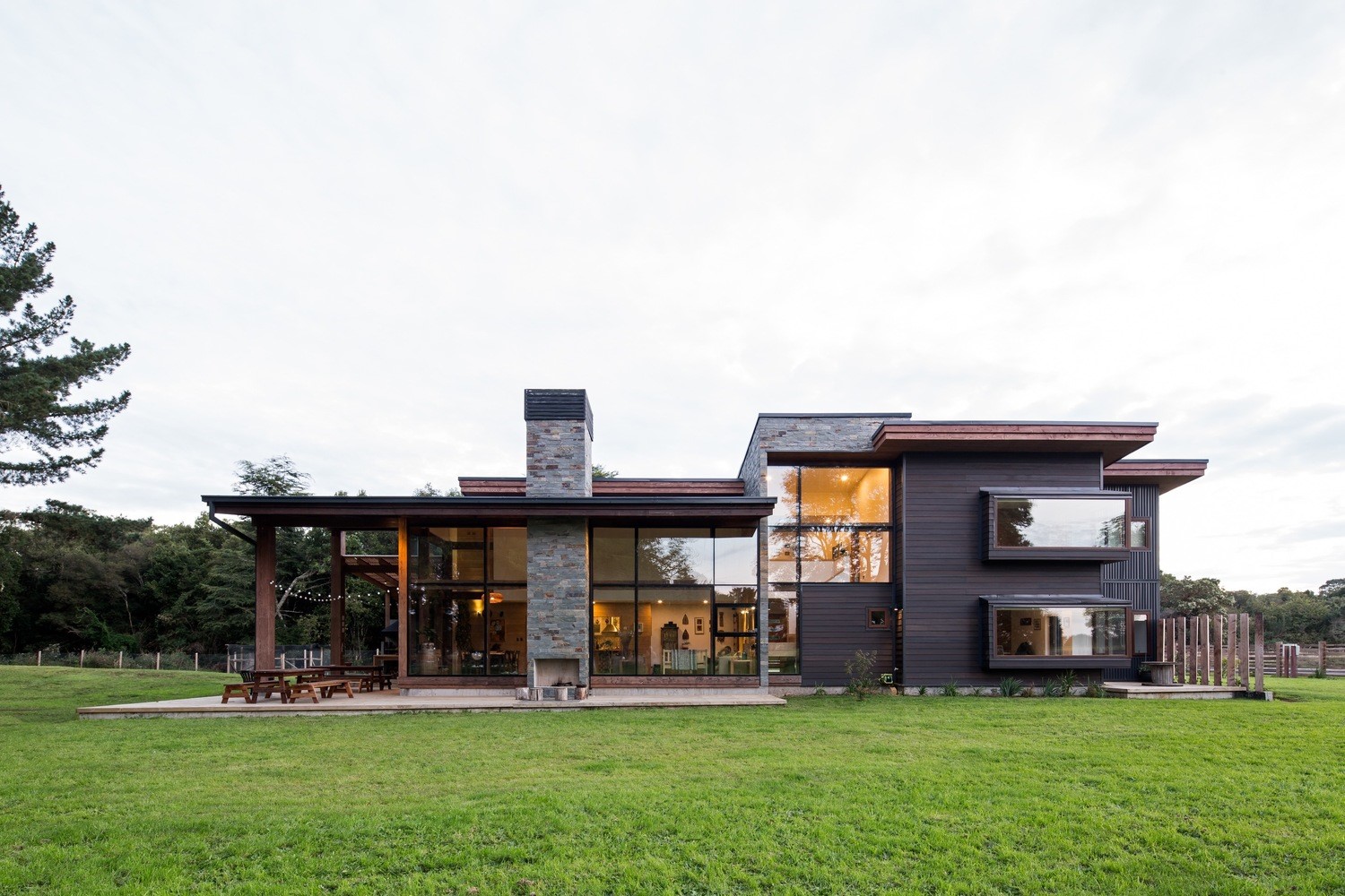 Modern house with large windows and stone chimney HD Wallpaper
