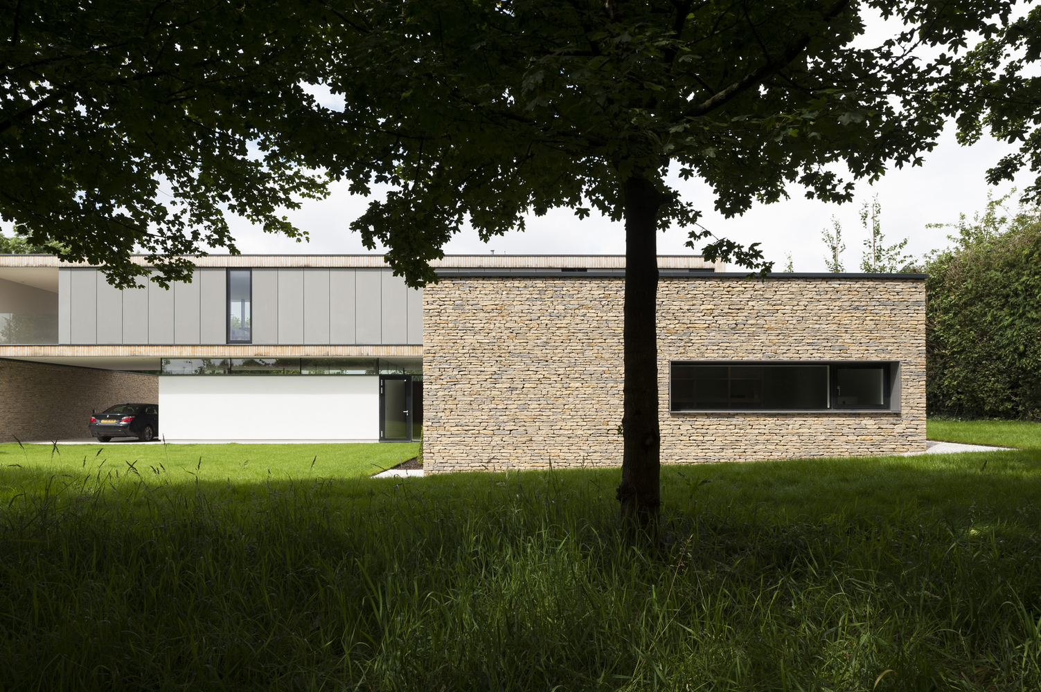 Modern house with stone facade and car in garage HD Wallpaper