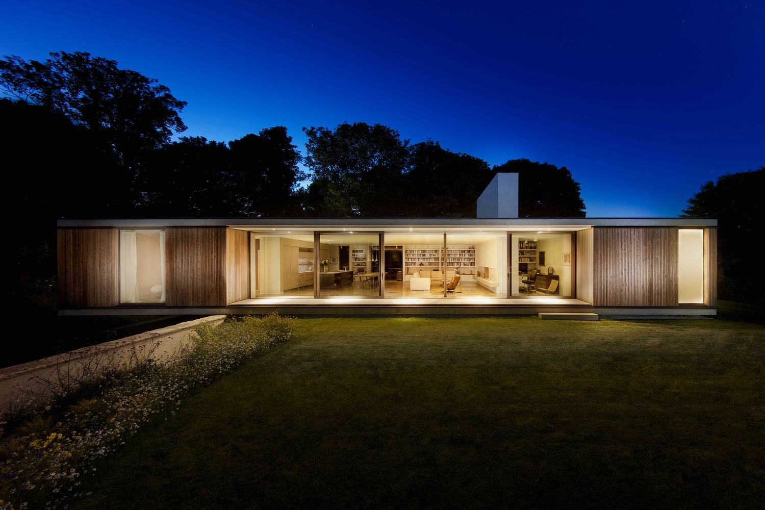 Modern house with glass walls at night HD Wallpaper