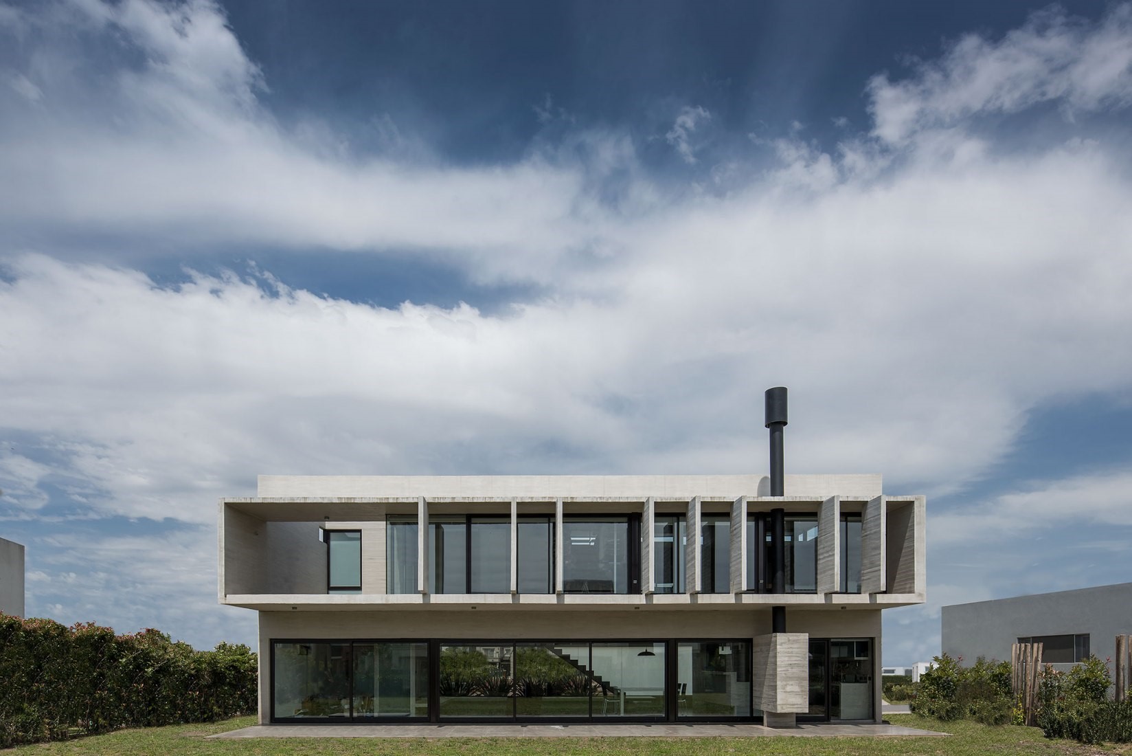 Modern concrete house with large windows and chimney HD Wallpaper