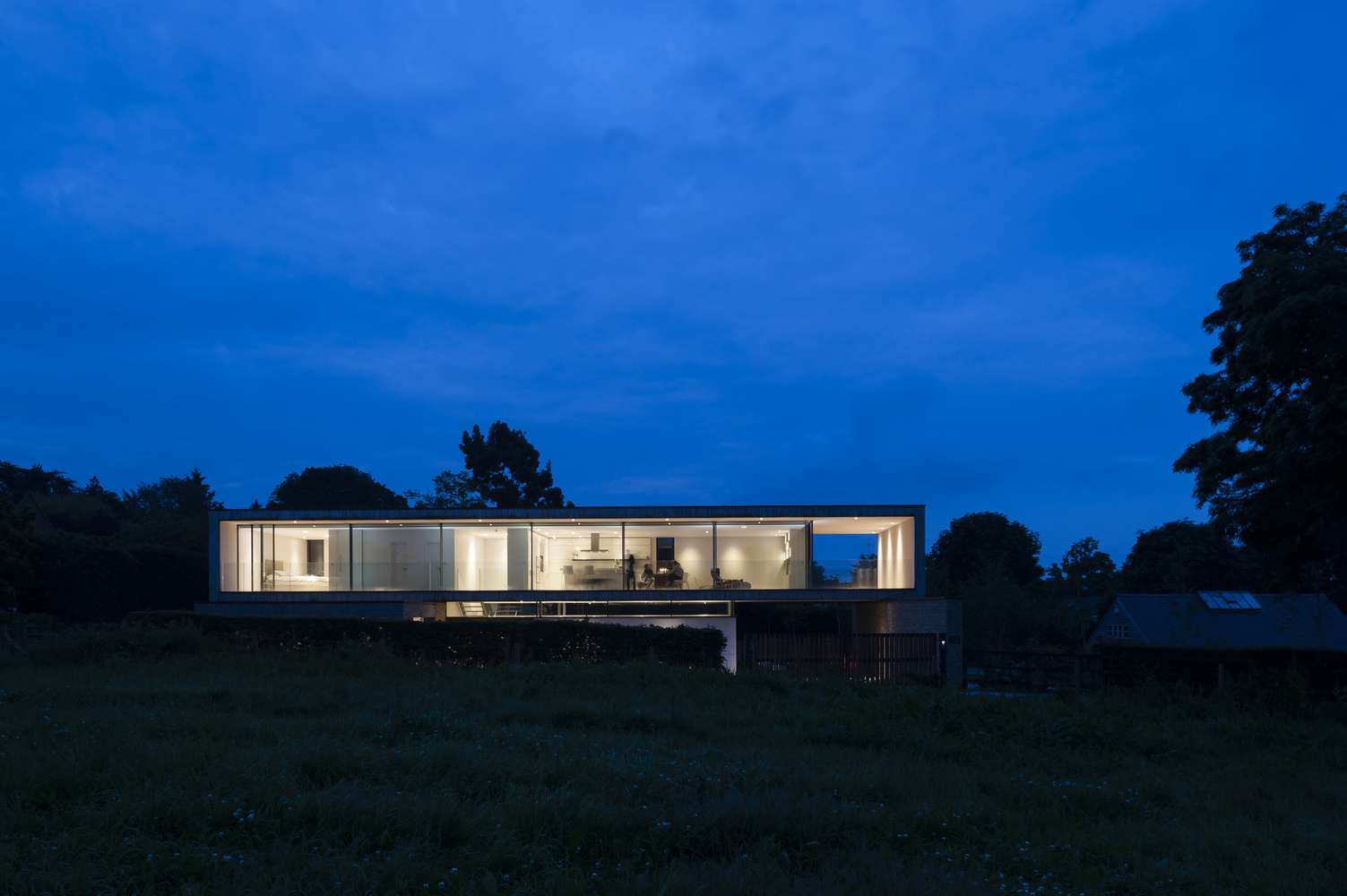 Modern luxury house with glass walls at dusk HD Wallpaper