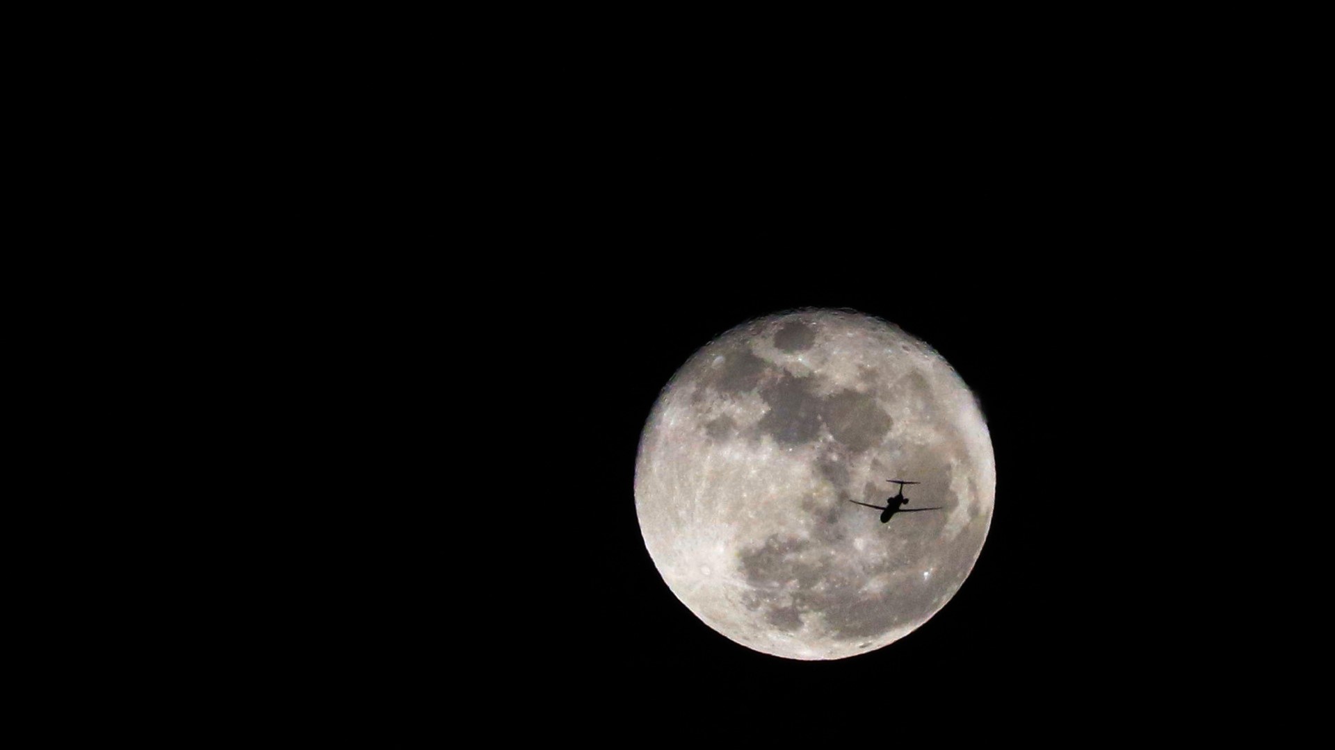 Airplane flying in front of the Moon at night HD Wallpaper