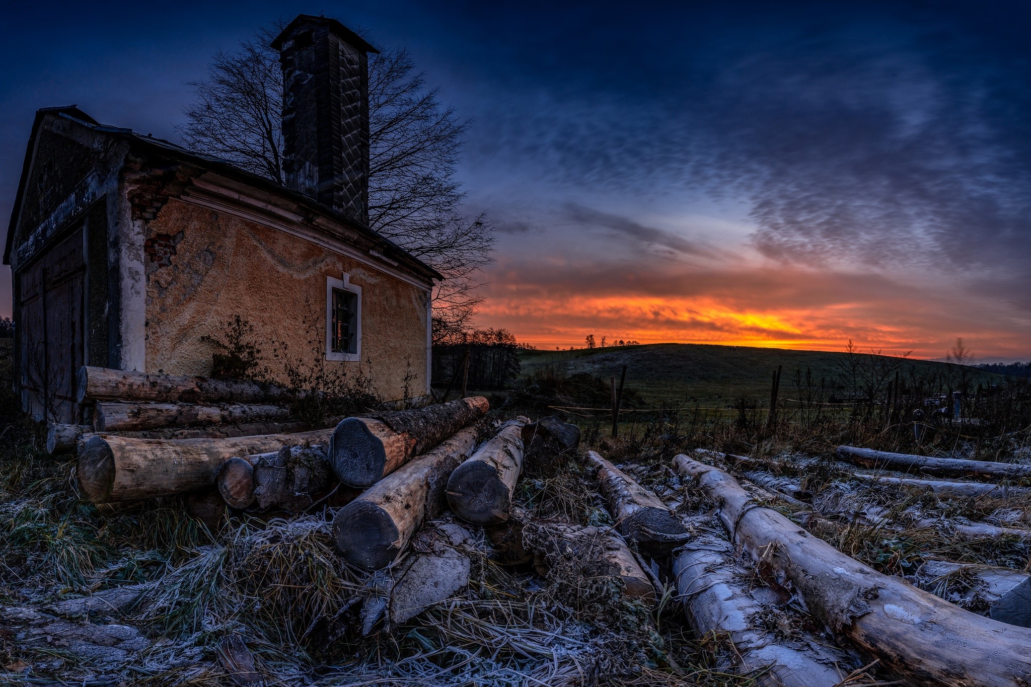 Abandoned building with logs at sunset HD Wallpaper
