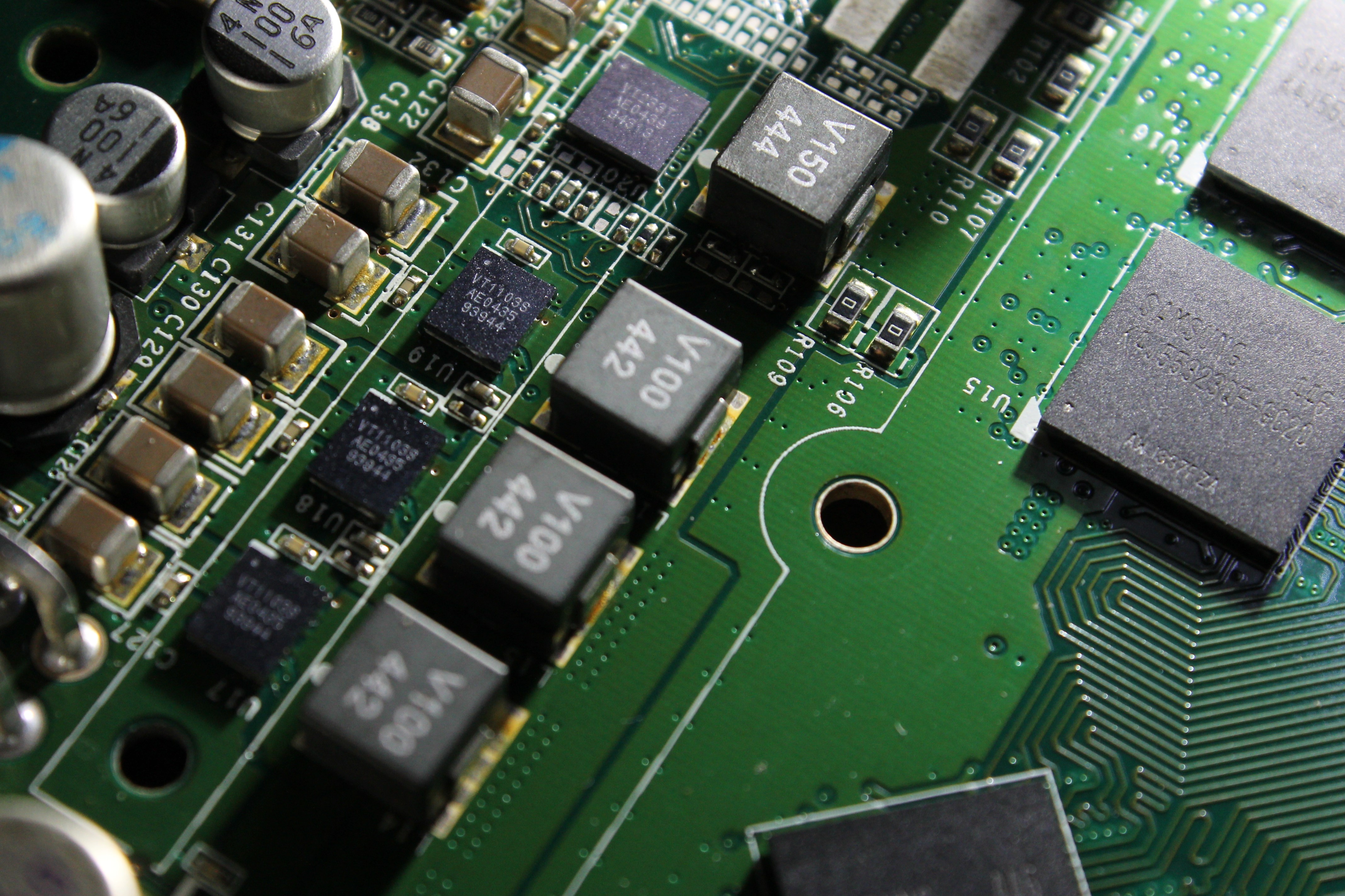 Close-up of a green circuit board with electronic components HD Wallpaper