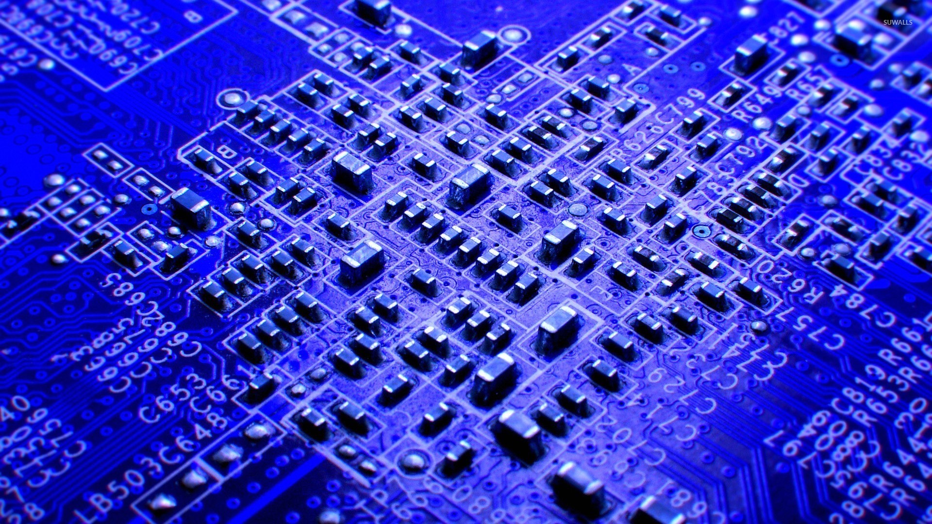 Close-up of a blue circuit board with many components HD Wallpaper