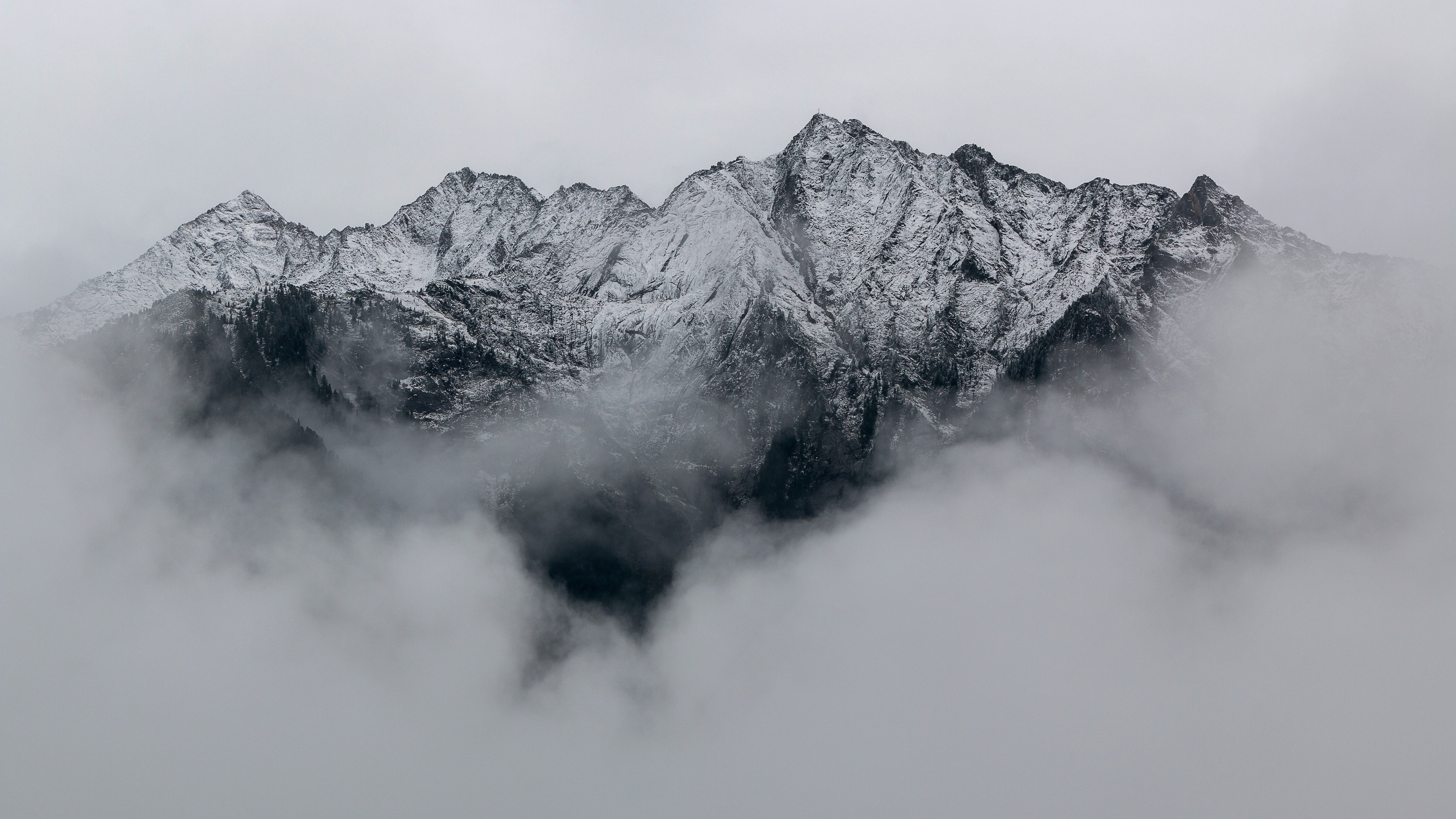 Snow-capped mountains shrouded in clouds HD Wallpaper