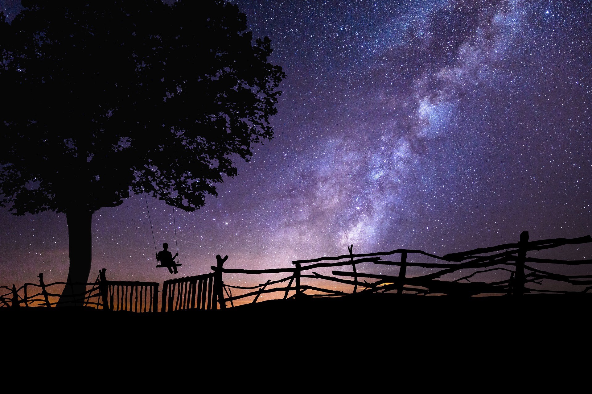 Silhouette of a person on a swing under a tree against the Milky Way HD Wallpaper
