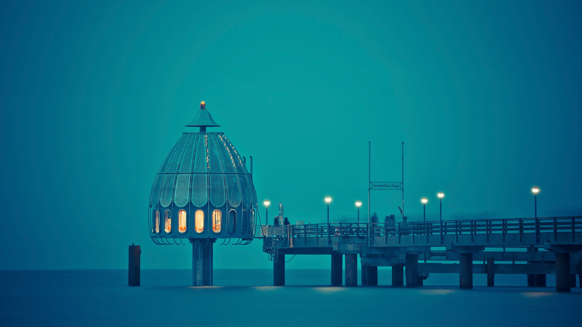 Pier with a glass dome structure at dusk HD Wallpaper