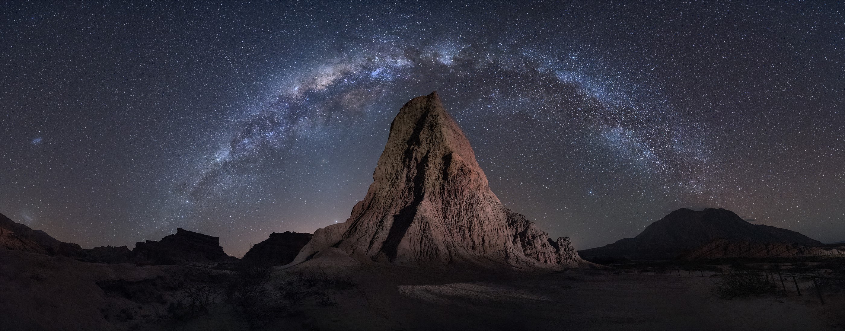Milky Way over a rocky desert landscape at night HD Wallpaper