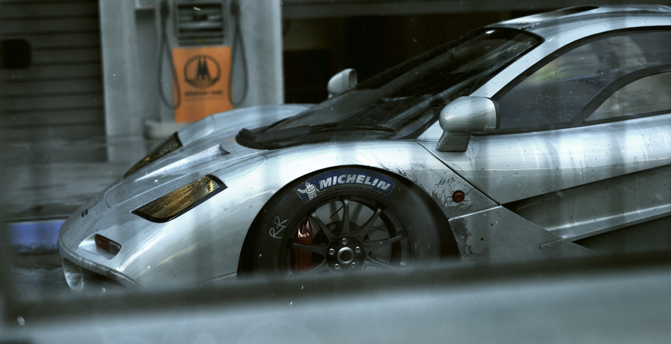 Silver McLaren F1 GTR race car at gas station HD Wallpaper