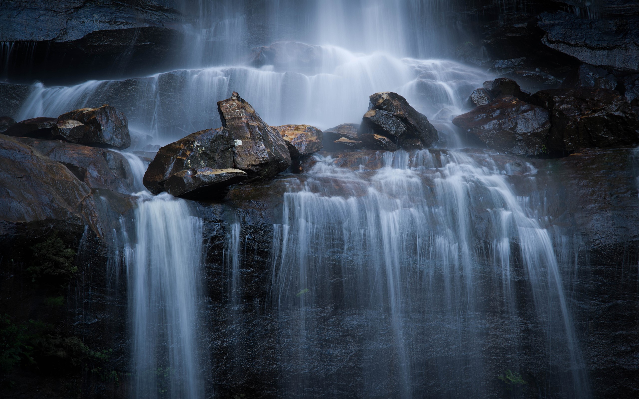 Waterfall cascading over wet rocks HD Wallpaper