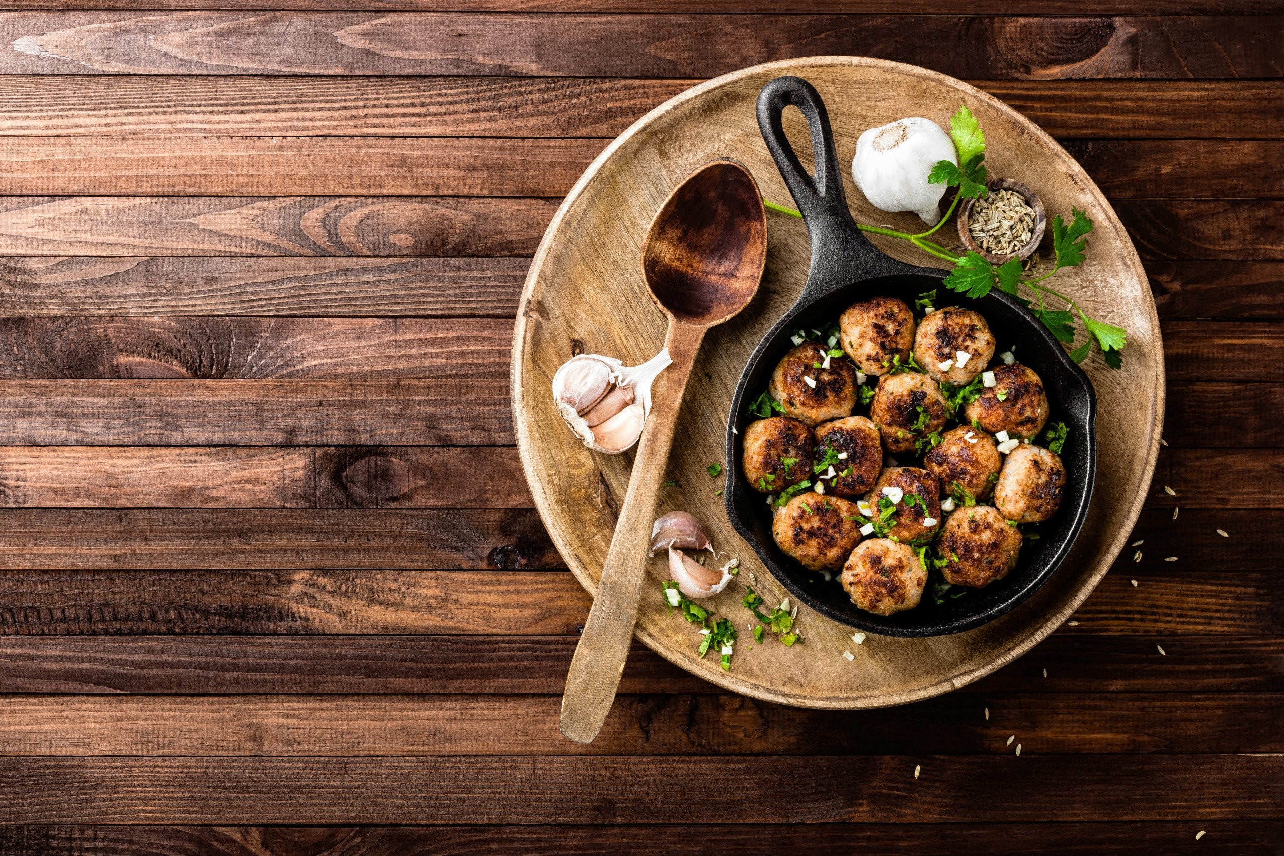 Meatballs in a cast iron skillet with garlic and herbs HD Wallpaper