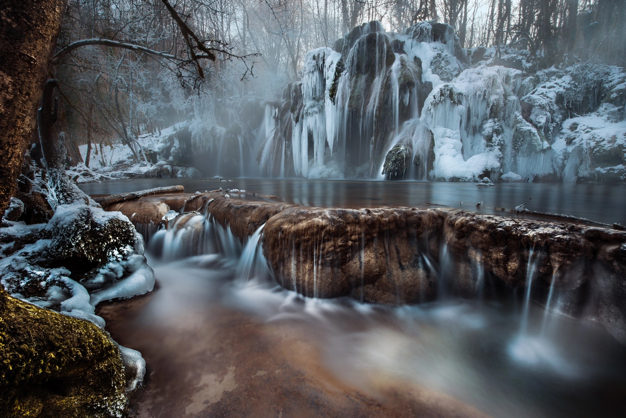 Frozen waterfall in a winter forest with ice formations HD Wallpaper