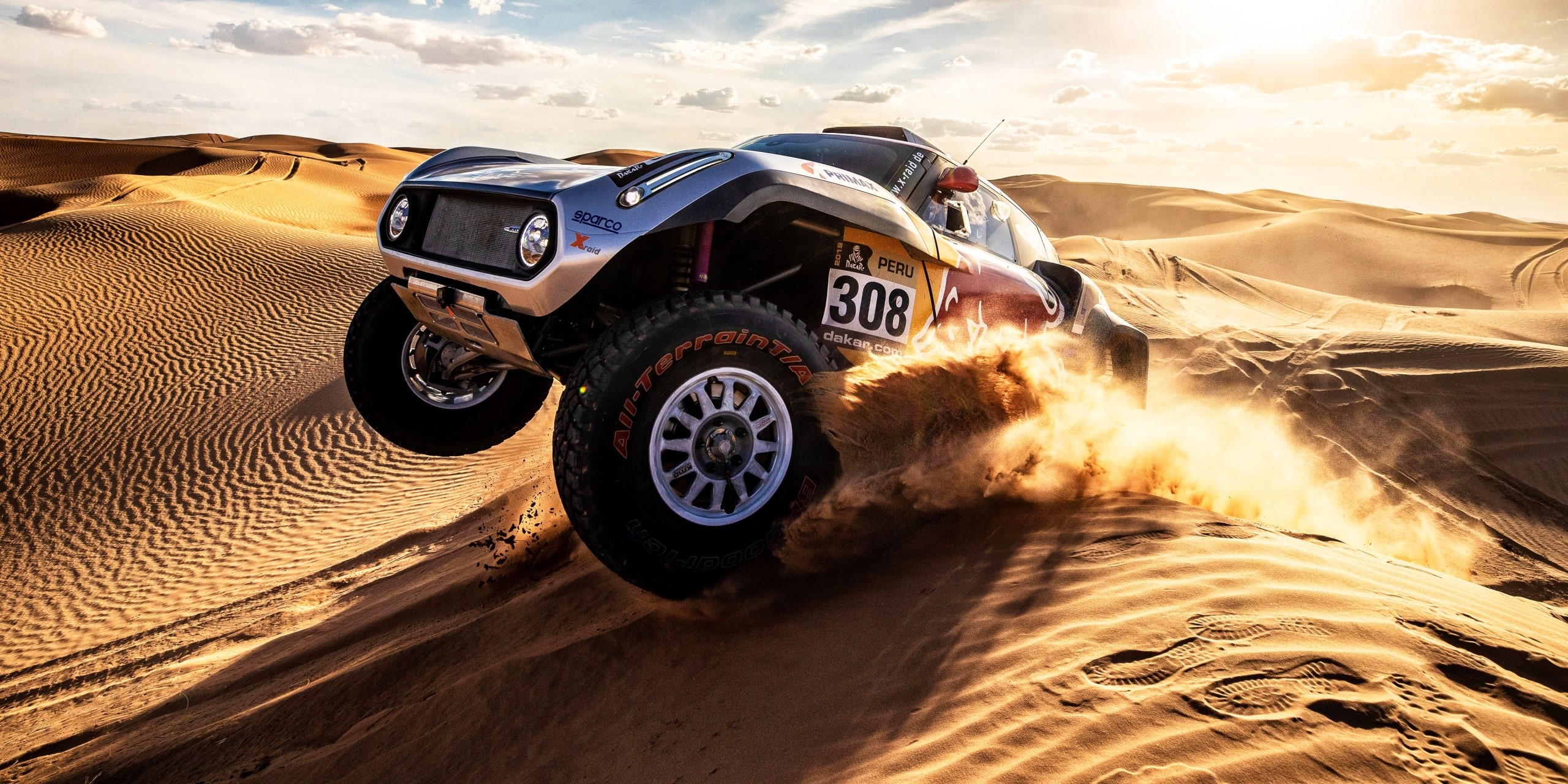 Rally car racing through desert dunes HD Wallpaper