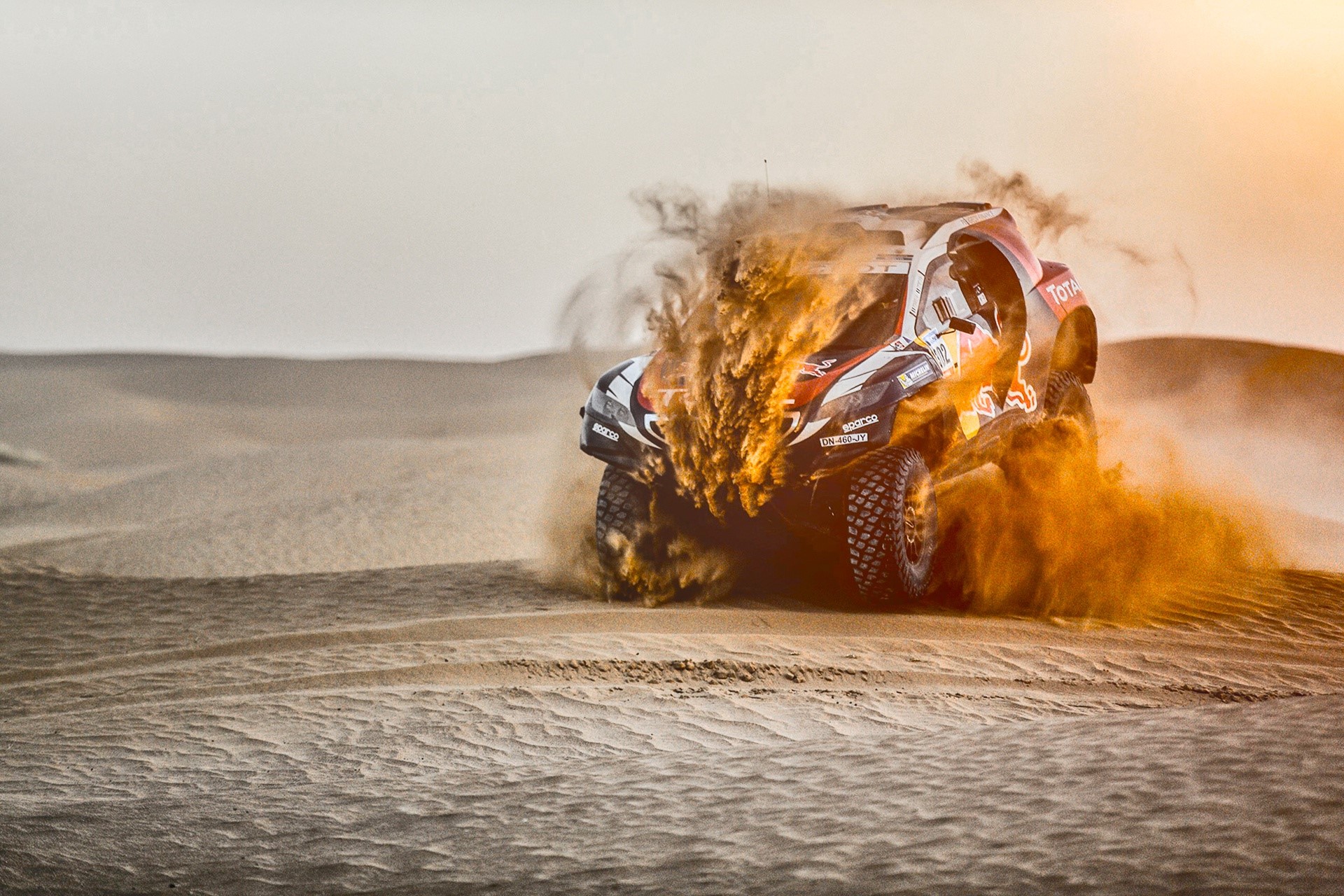 Peugeot rally car racing through desert sand HD Wallpaper