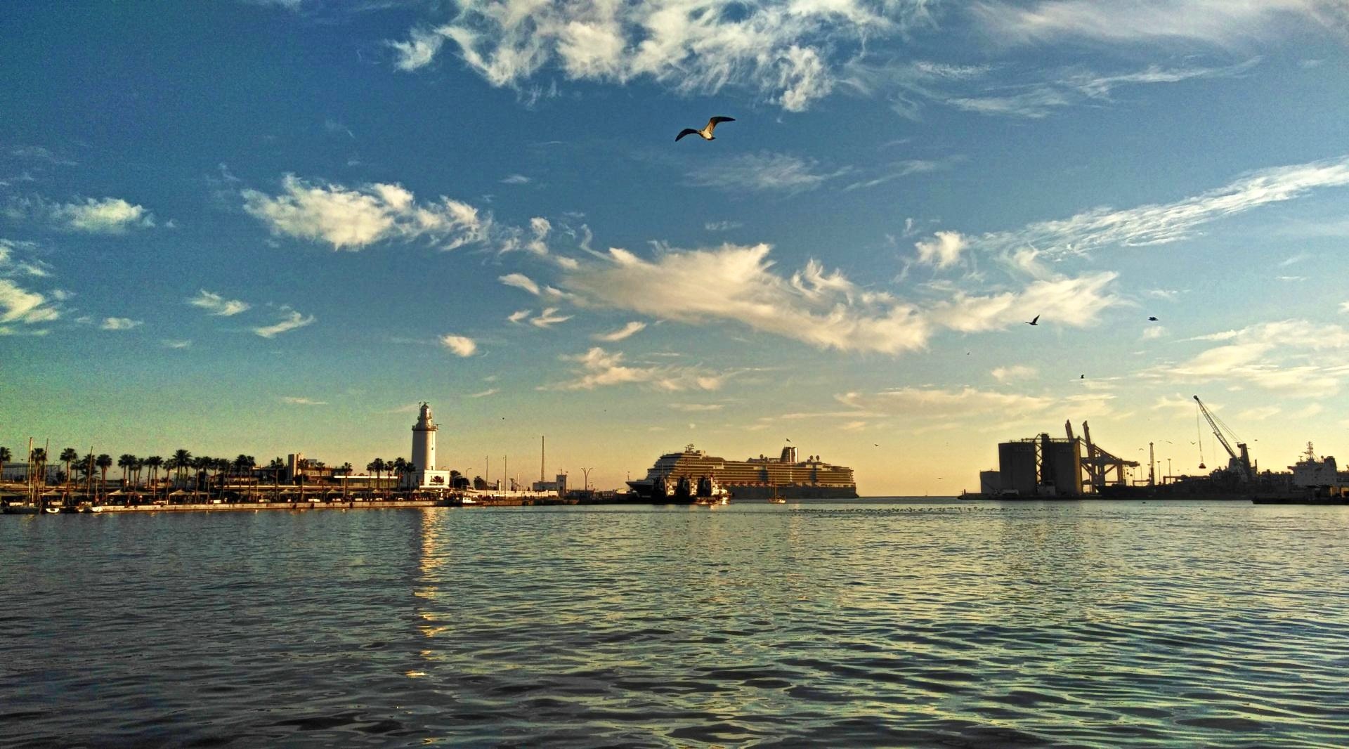Malaga lighthouse and harbor at sunset with seagulls HD Wallpaper
