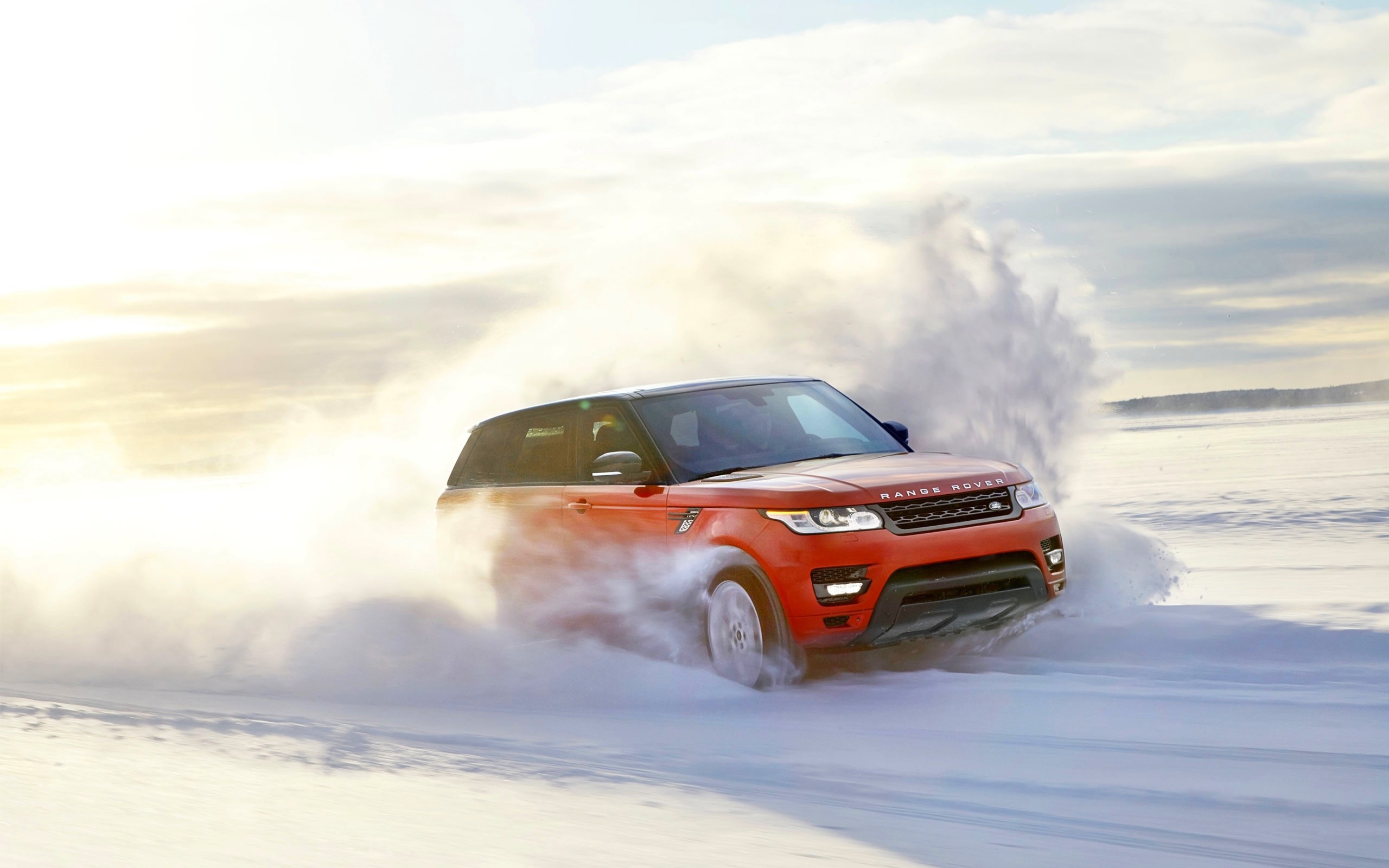 Red Range Rover driving through snow HD Wallpaper