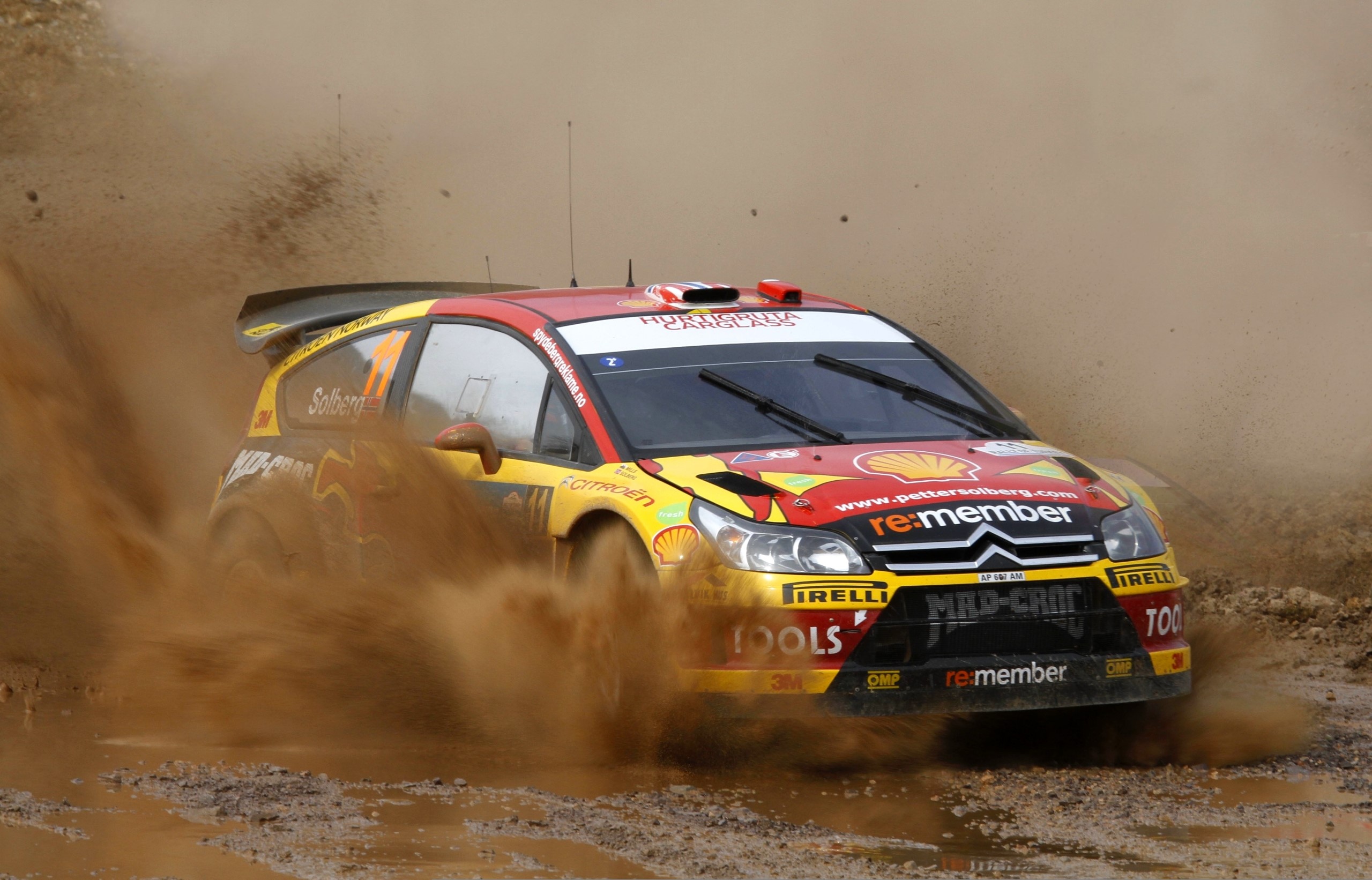Petter Solberg's Citroen C4 WRC car racing through dirt HD Wallpaper