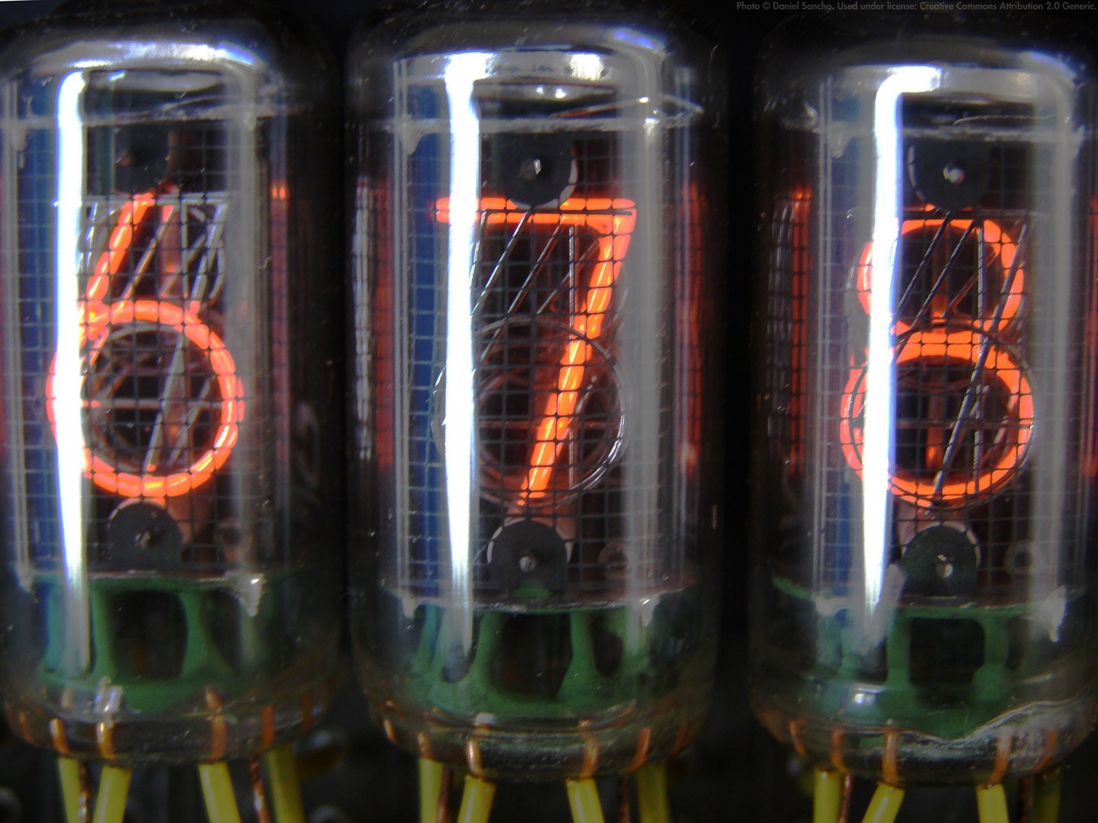 Close-up of three glowing Nixie tubes displaying numbers HD Wallpaper