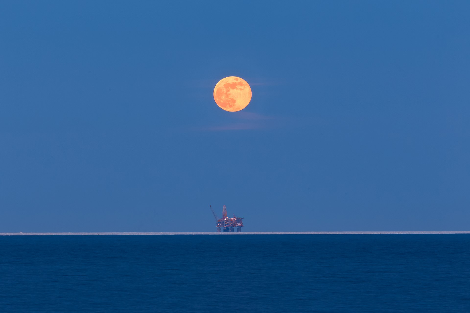 Orange moon over oil platform on the sea HD Wallpaper