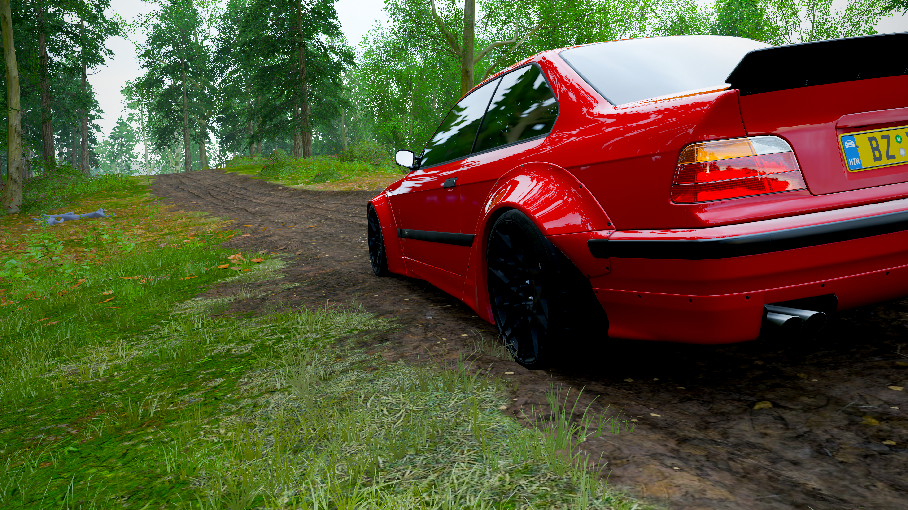Red BMW 3 Series on a dirt road in a forest HD Wallpaper
