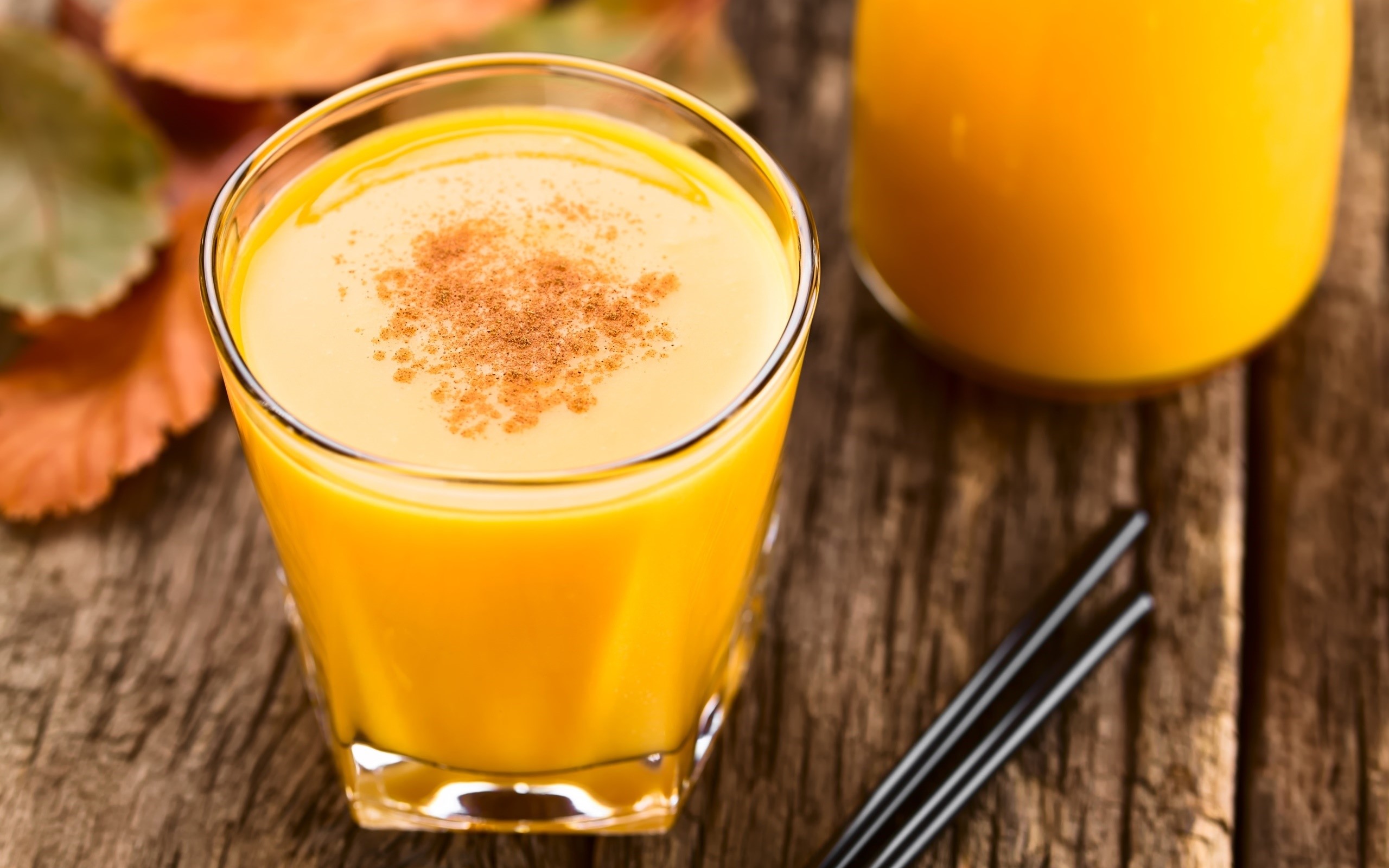 Orange juice with cinnamon on a wooden table HD Wallpaper