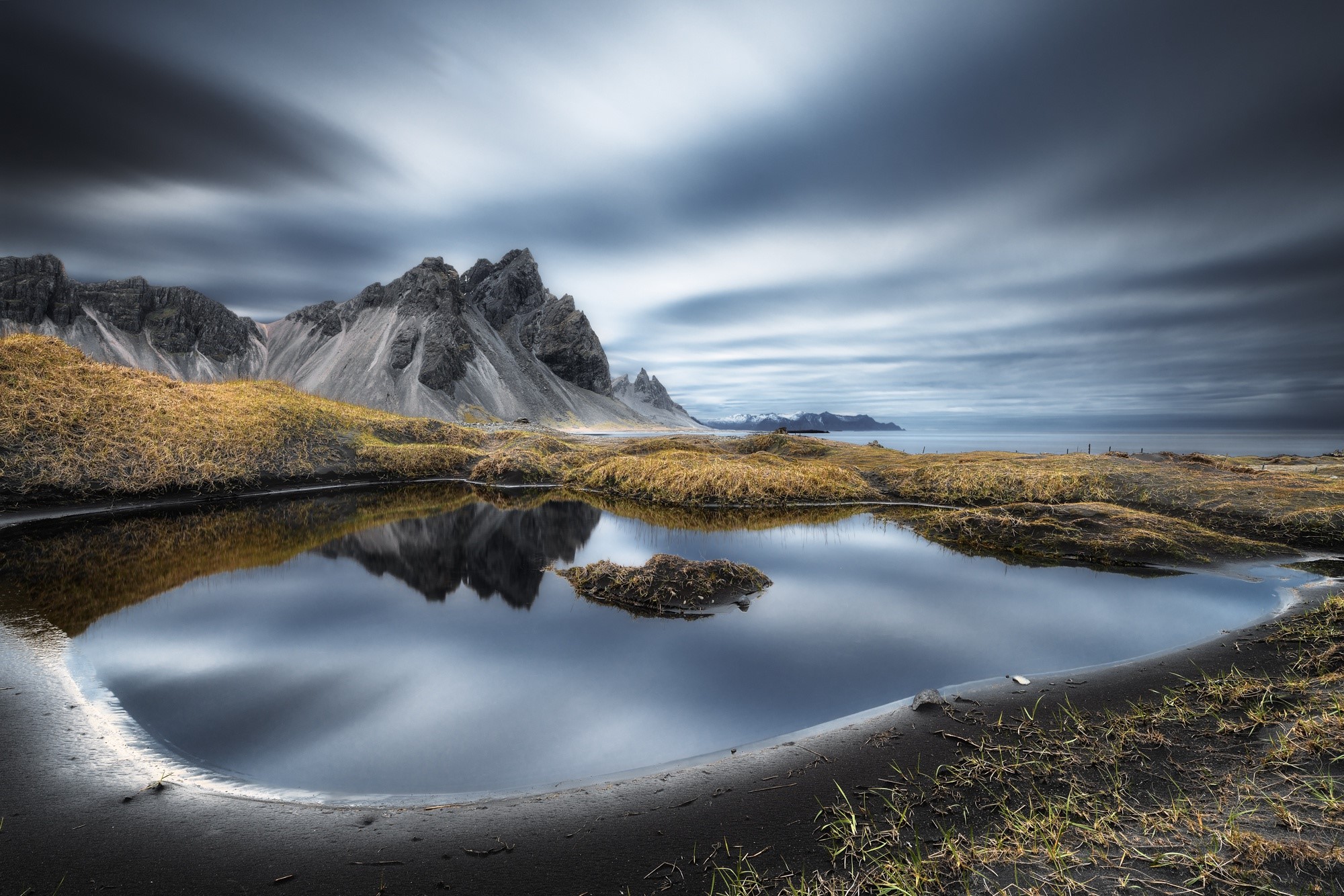 Jagged mountains reflected in a tidal pool in Iceland HD Wallpaper